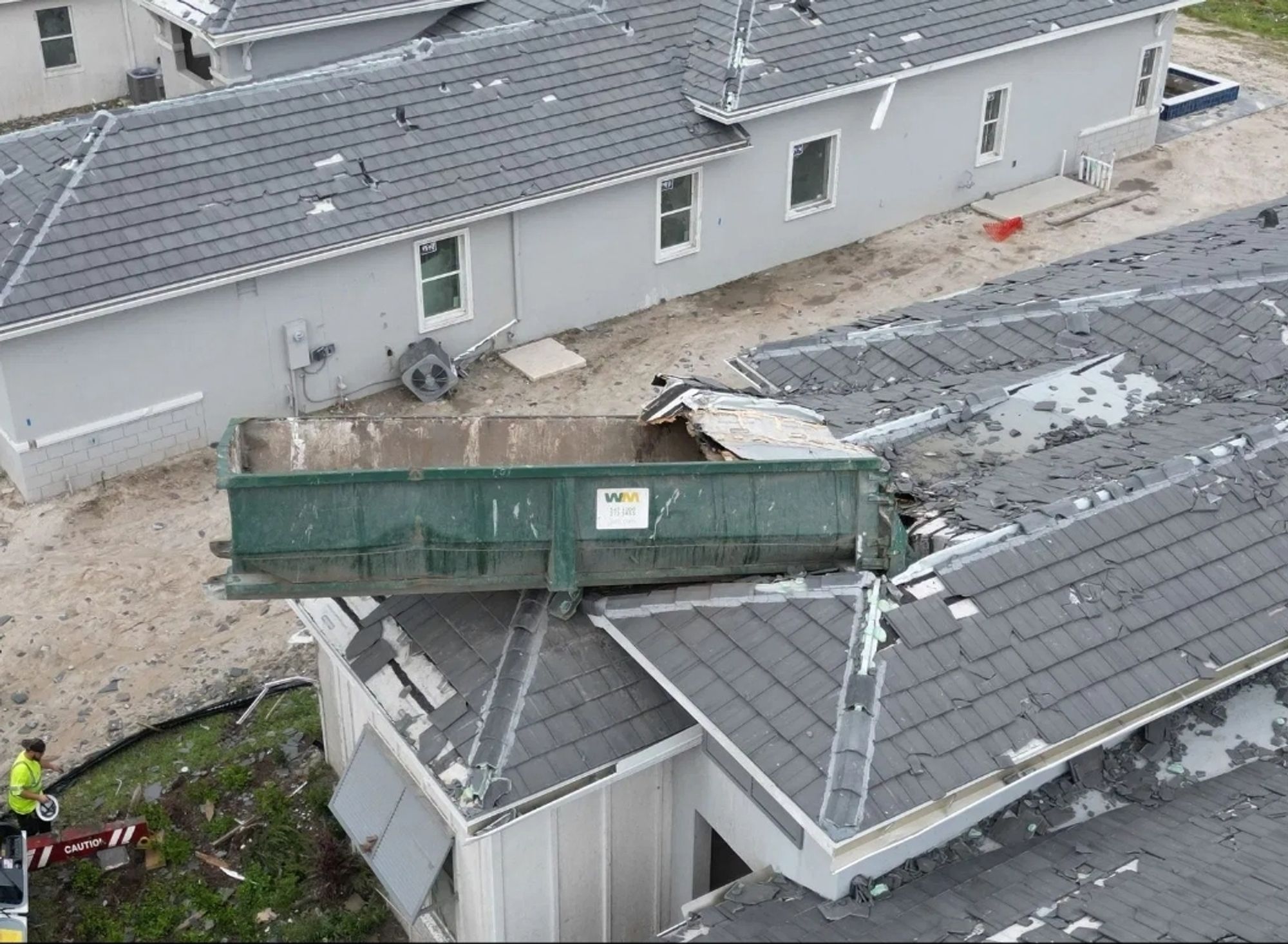 House with dumpster flung on it by a tornado