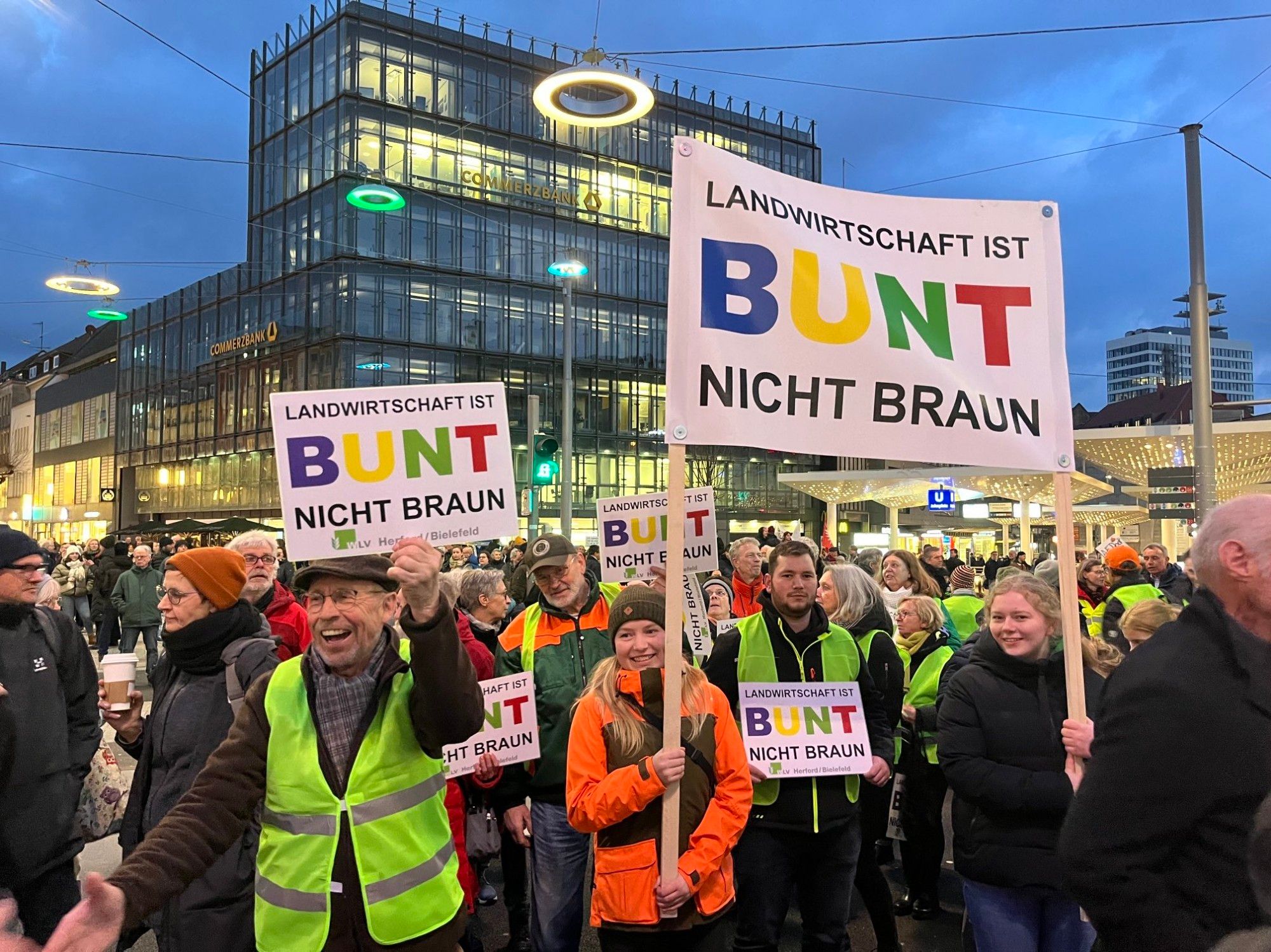 Das Bild zeigt viele Menschen bei der Demo gegen Rechts in Bielefeld. Vorne sind Schilder zu sehen, mit der Aufschrift: Landwirtschaft ist Bunt nicht Braun.