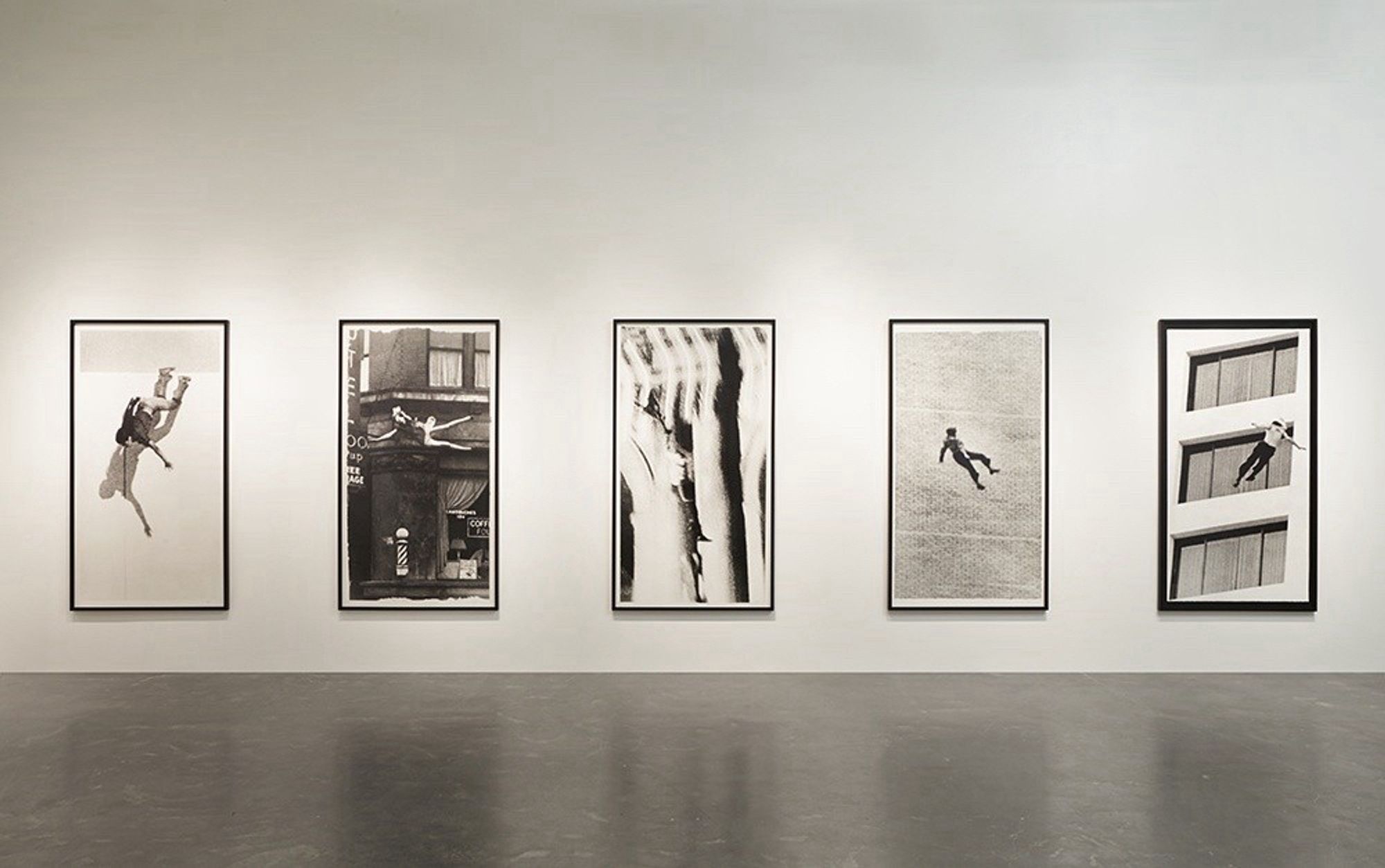 Museum view of 5 large grainy prints of falling bodies.