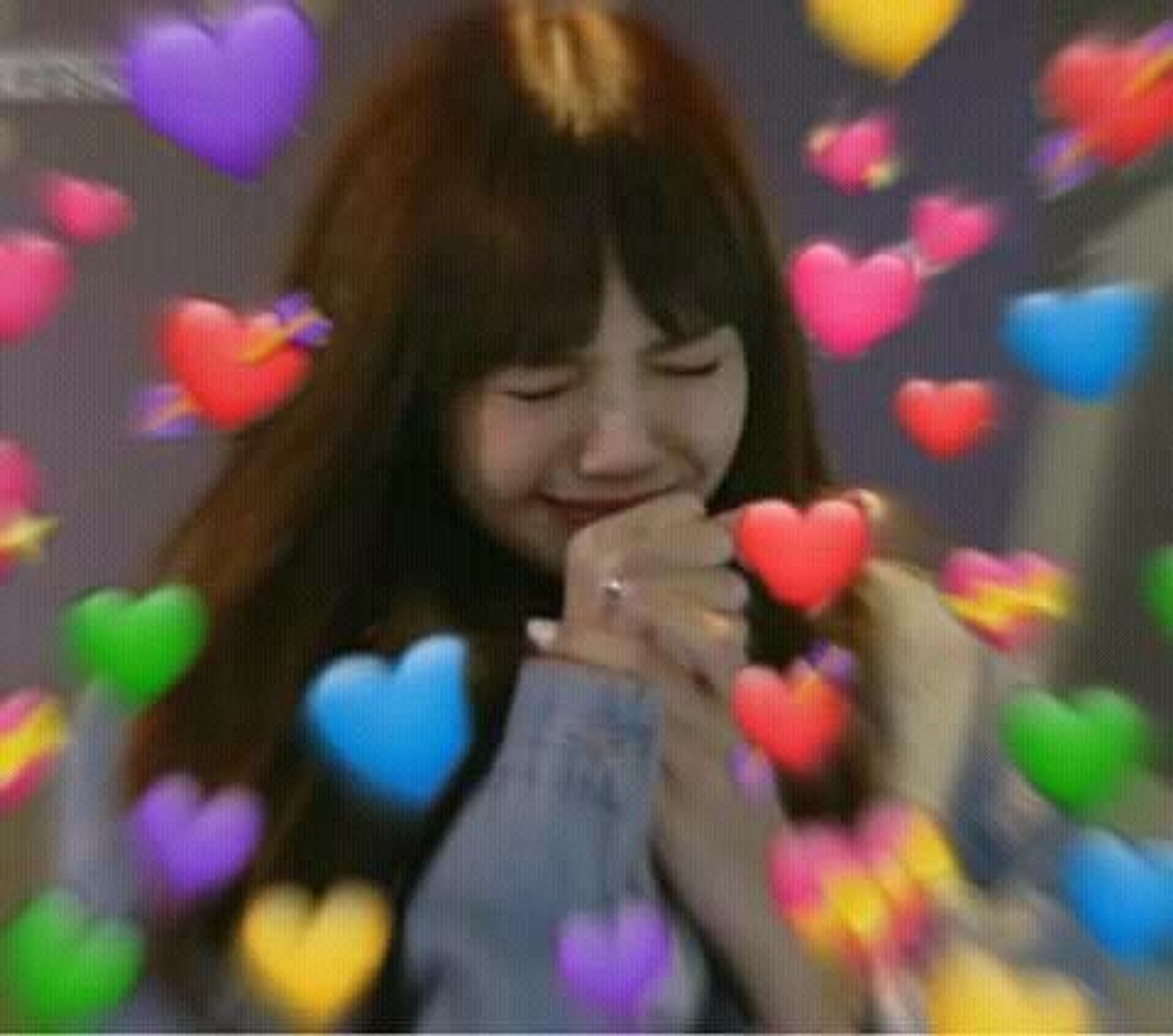 Lisa from BLACKPINK clasping her hands in a grateful pose with emoji hearts surrounding her