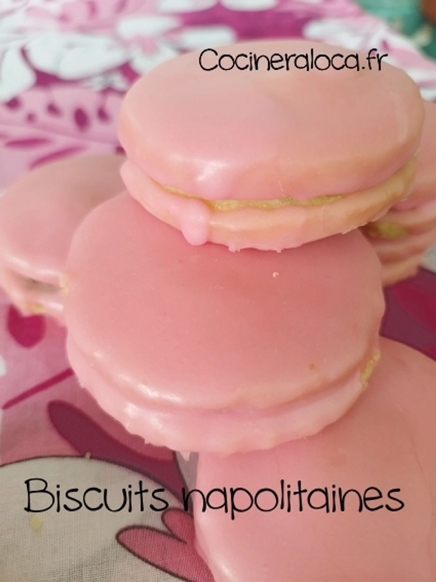 Quelques biscuits napolitaines recouverts de glaçage rose Barbie posés sur une nappe.