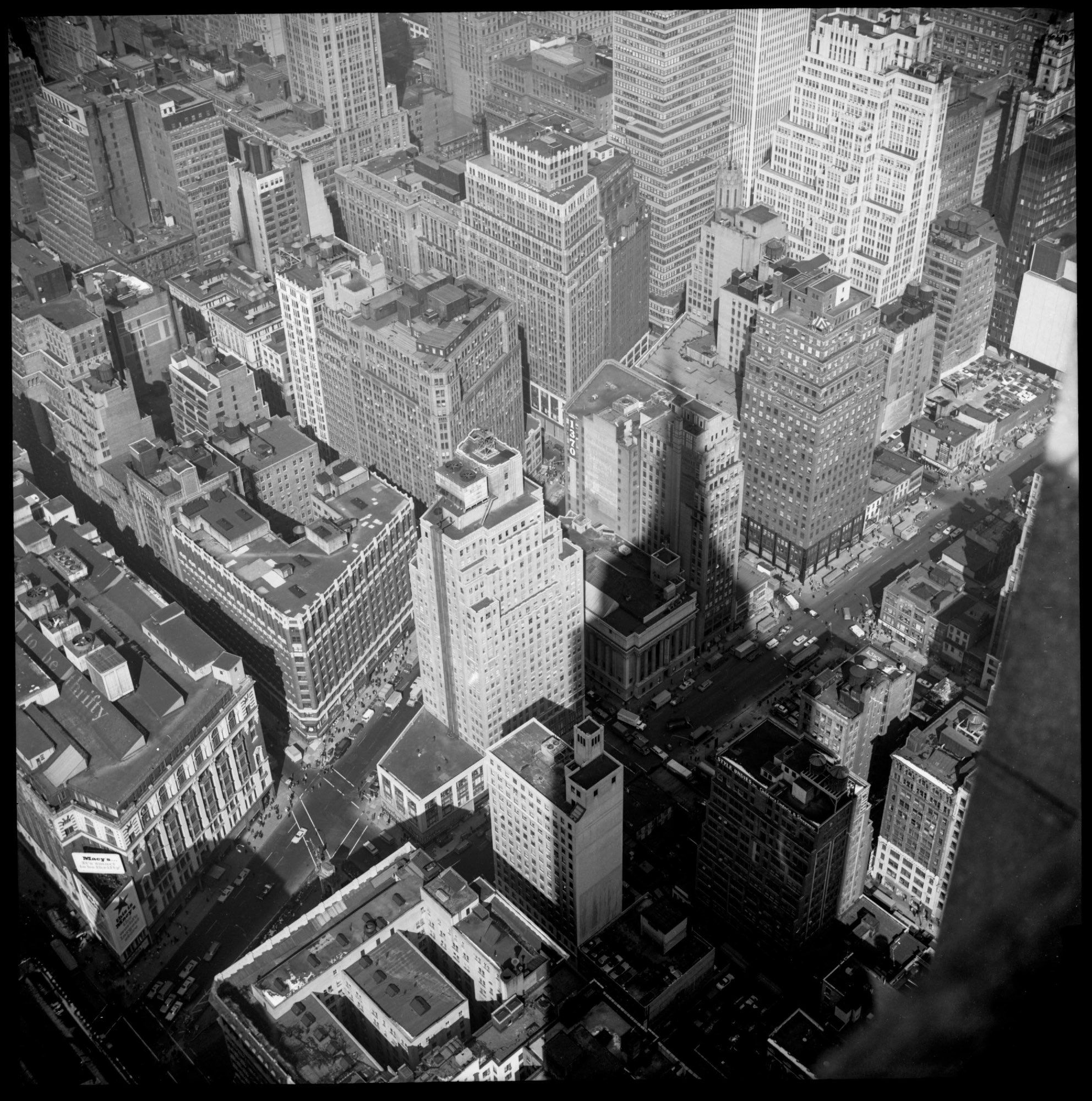 Casting a Shadow. In doing the edits on this I noticed details, such as seeing people on the street, storefront signs, and that someone had written “BEATLES” on one of the building rooftops. One business sign proudly states, “STYLE UNDIES inc. Children’s Lingerie and Sleepwear”.