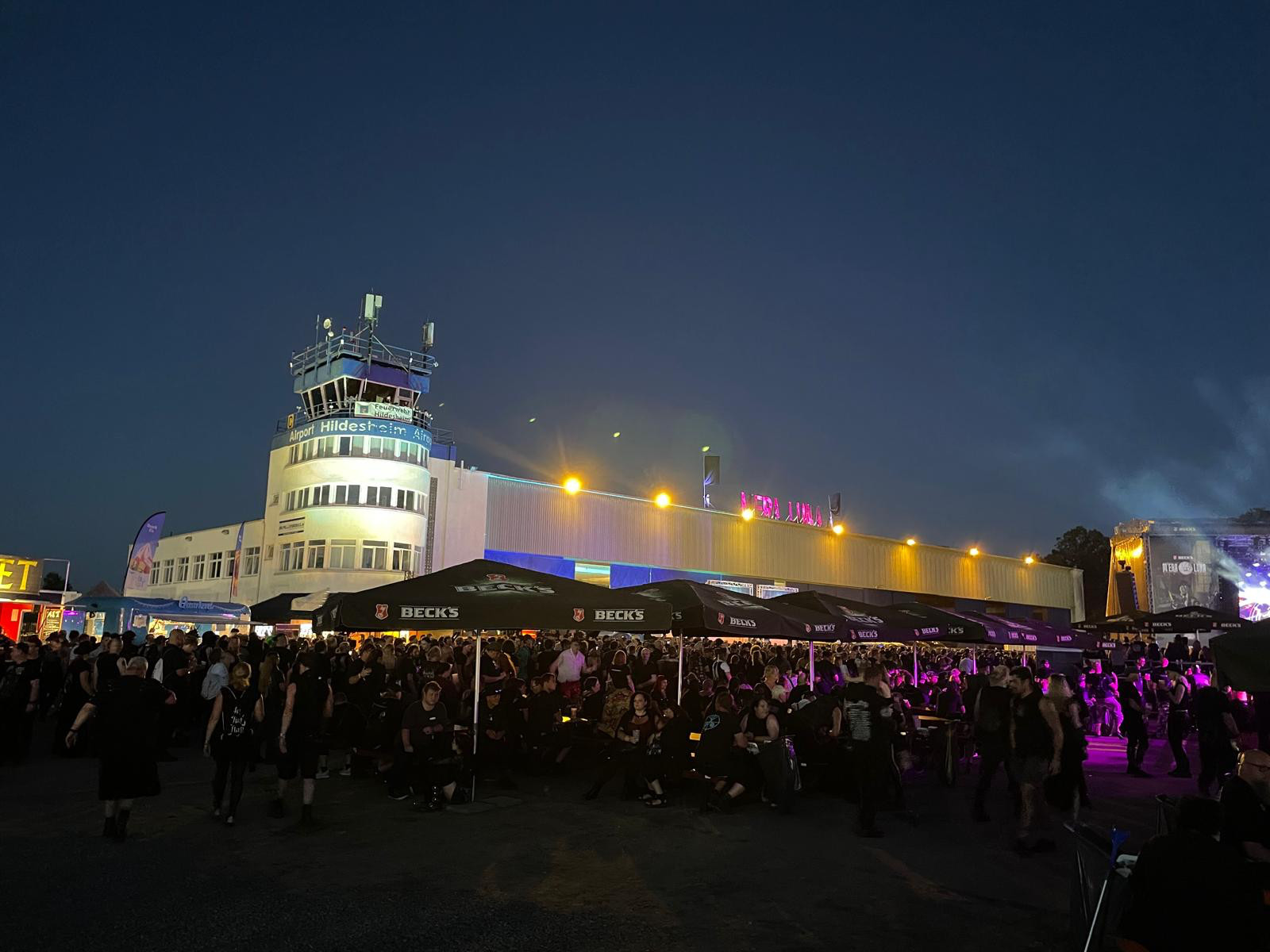 Hauptgebäude Hildesheim Airport mit Tower bei Nacht, erleuchtet von Scheinwerfern