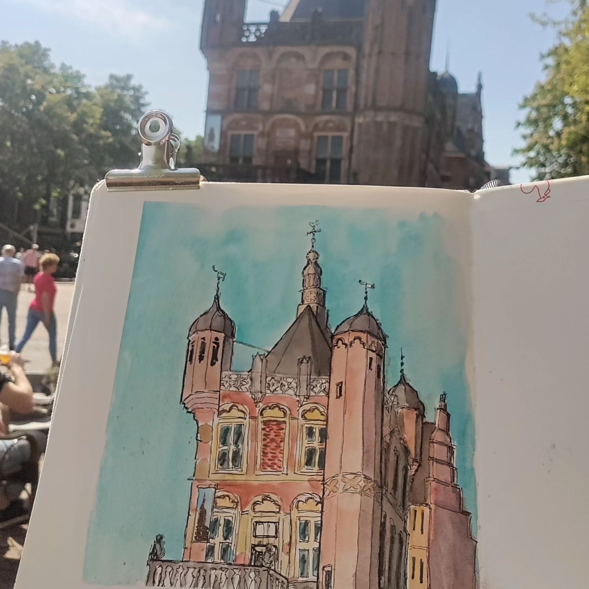 Square watercolor sketch of De Waag Museum in Deventer, NL in front of the building