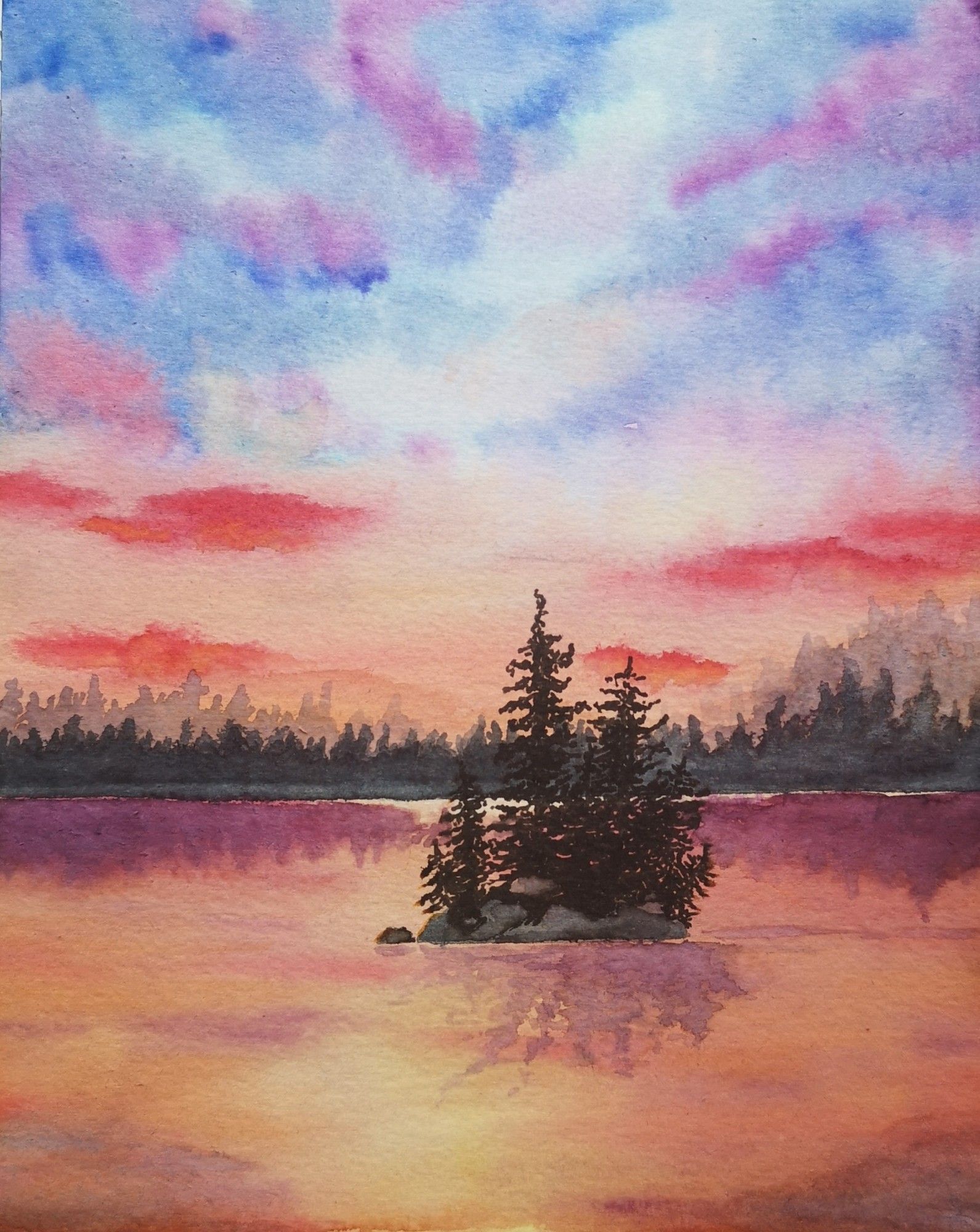 A small isle with firs in a lake at blue-violet-orange sunset which reflects in the water, northwest American nature scene