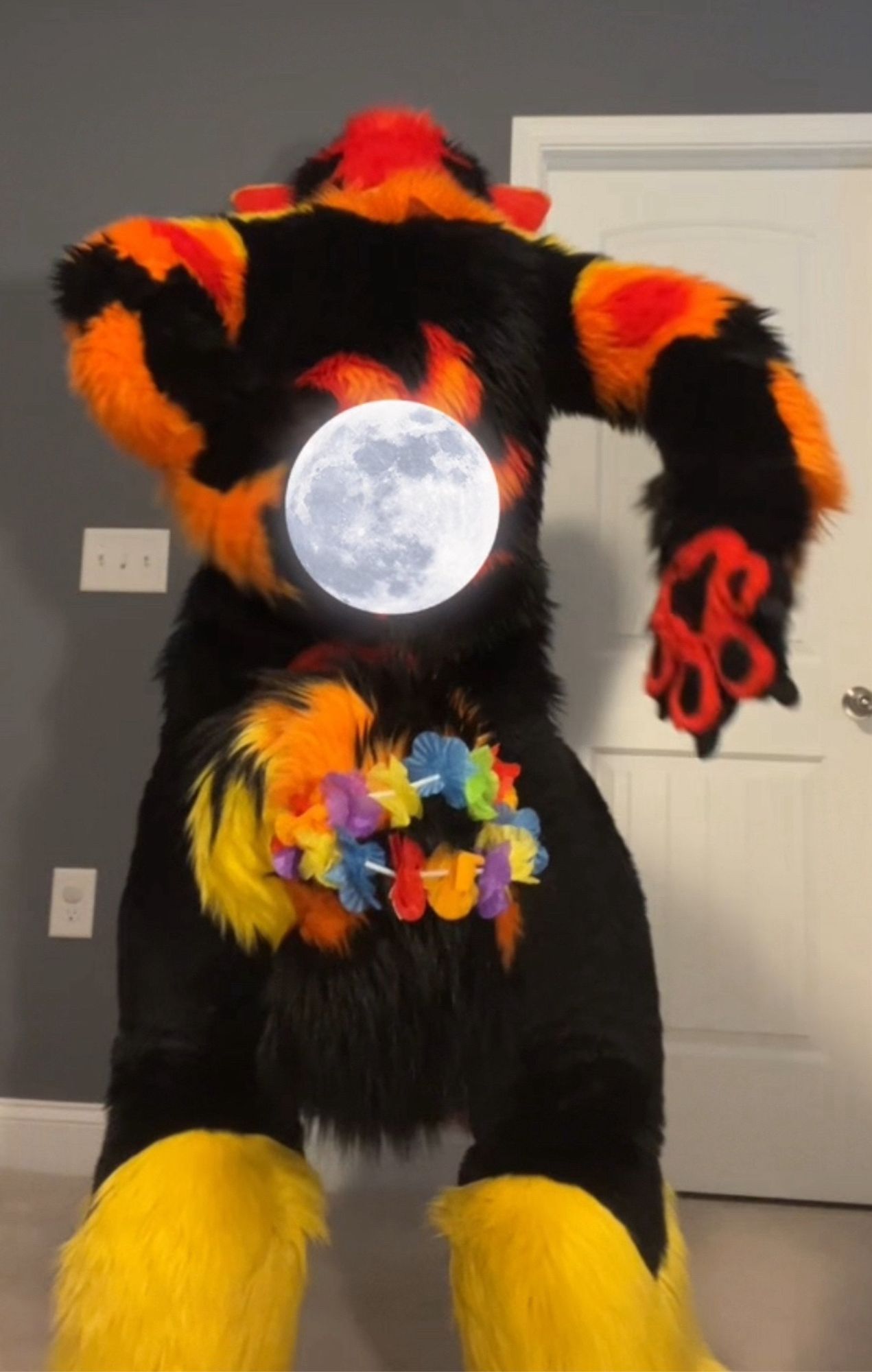 Solar fire husky fursuiter with moon sticker eclipsing their back sun tattoo.