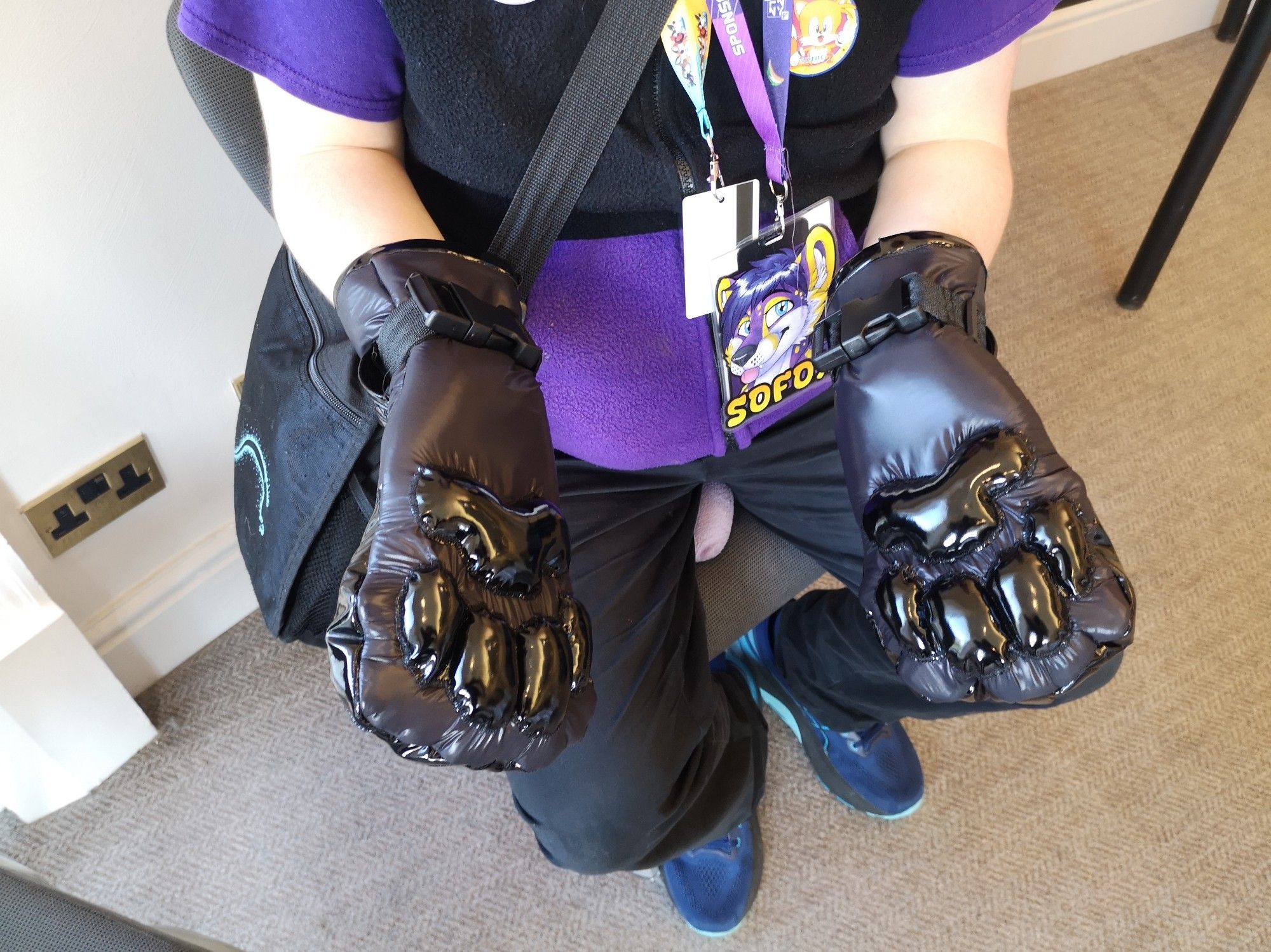 Shiny black vinyl mittten paw gloves being worn with straps on the wrists. Badge on wearer says "Sofox". Fi messenger bag from DMFA also worn.