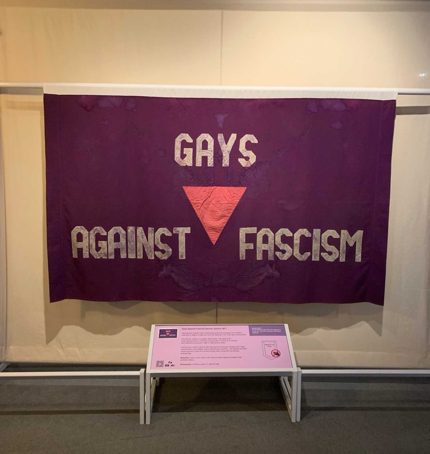 A large hanging banner saying “Gays against fascism” with an upside down triangle in the middle.