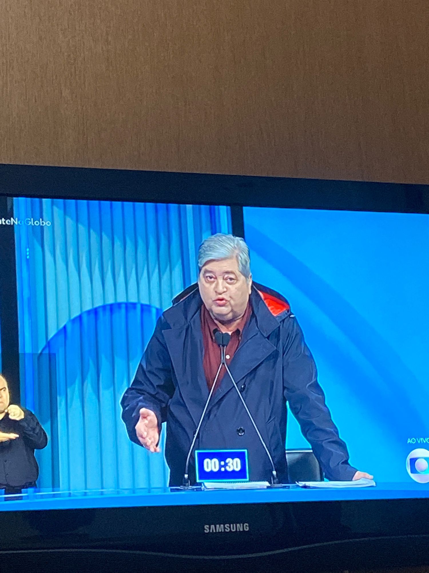 datena no debate usando um casaco preto com a parte de dentro do capuz vermelha, o que faz parecer muito a capa do drácula