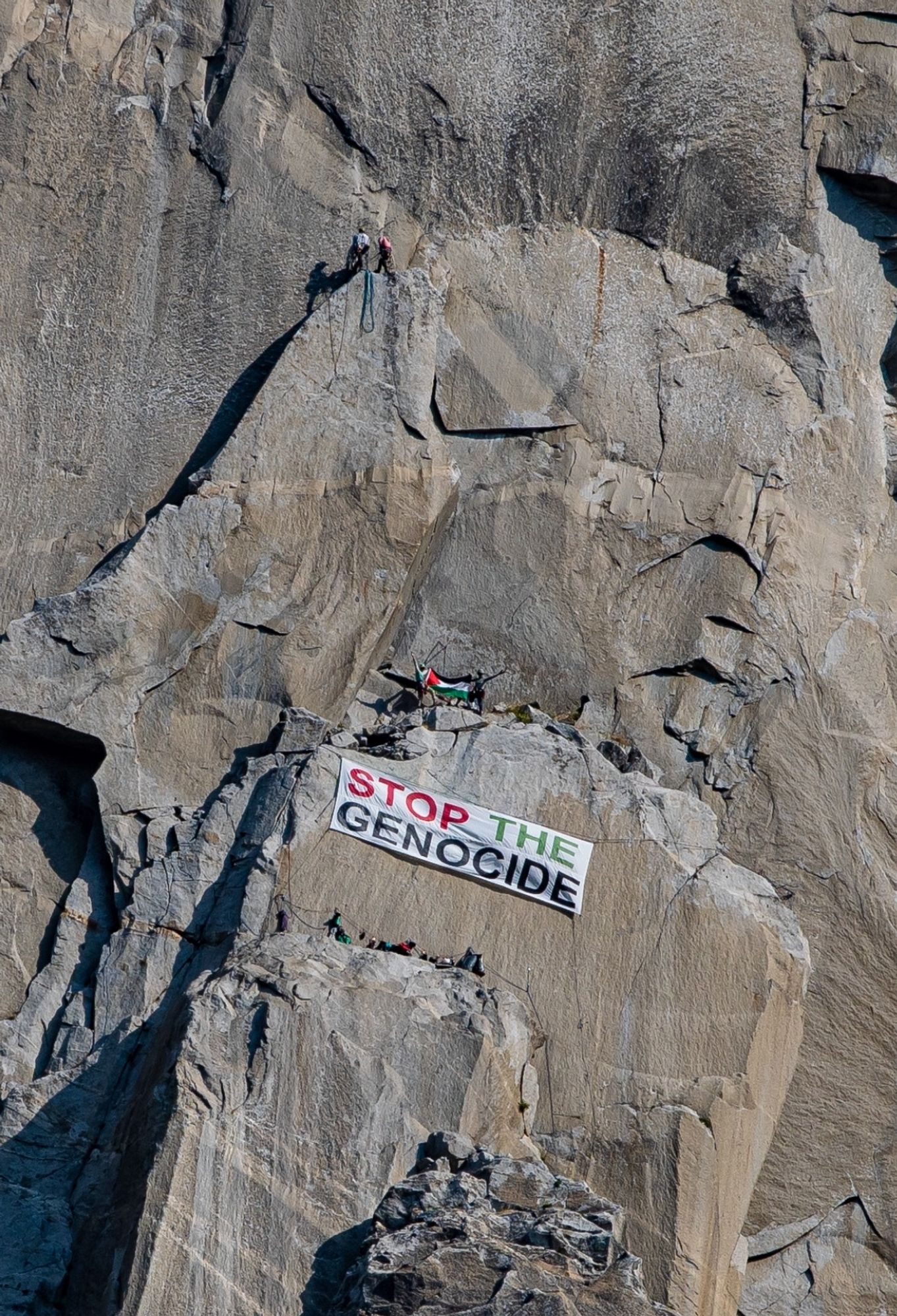 ‘Stop the Genocide’ banner on El Capitan mountain, with Palestinian flag waving on a cliff above.