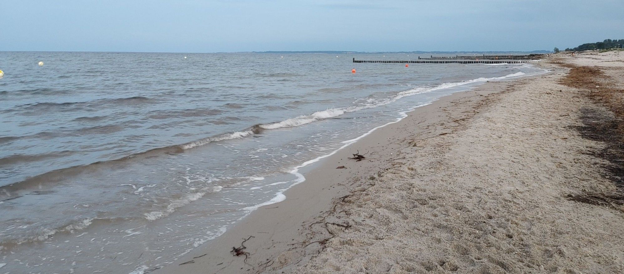 Ostseestrand am Abend. Wellen laufen auf den Sgrand auf.