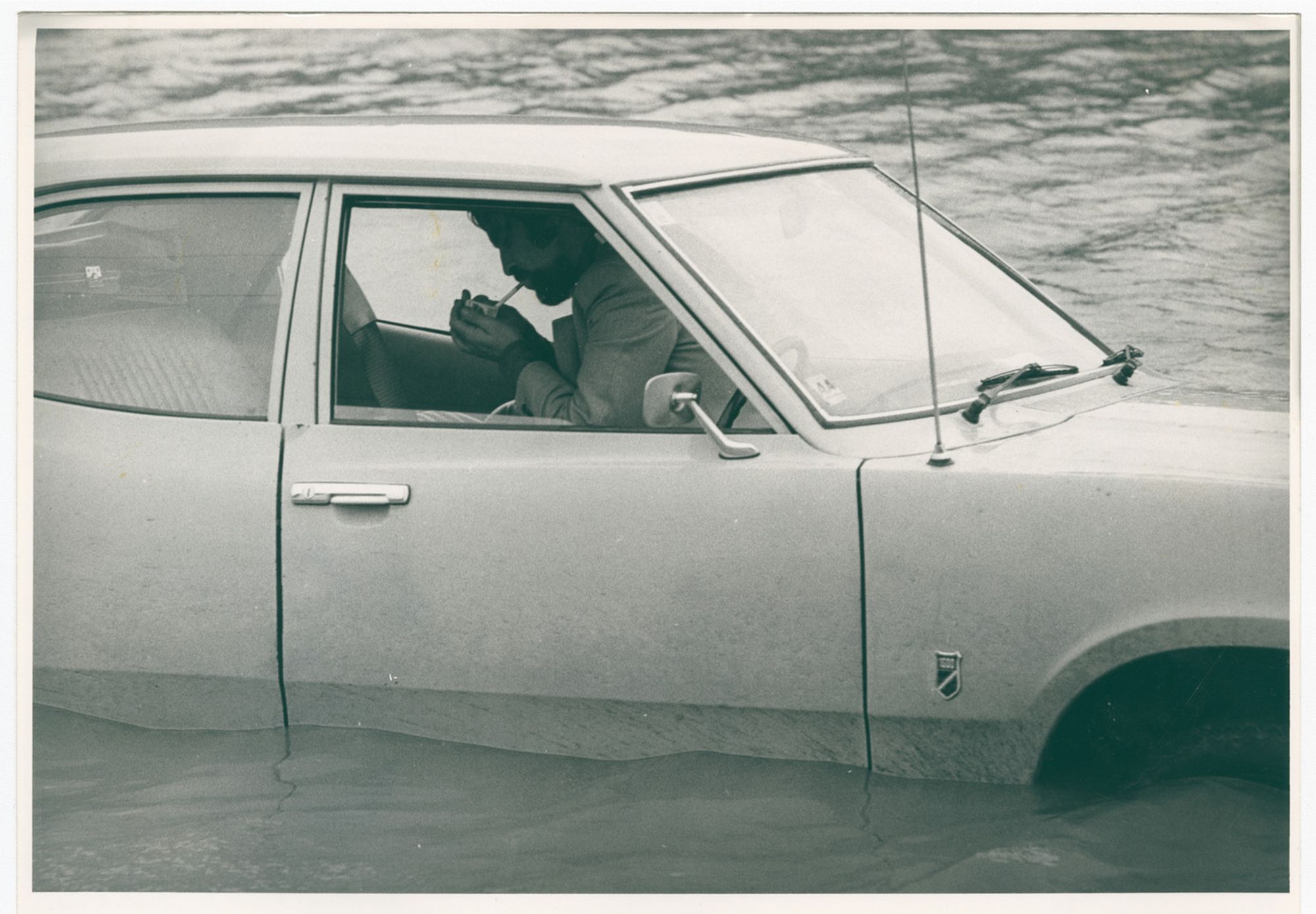 fella lighting up in a ford cortina