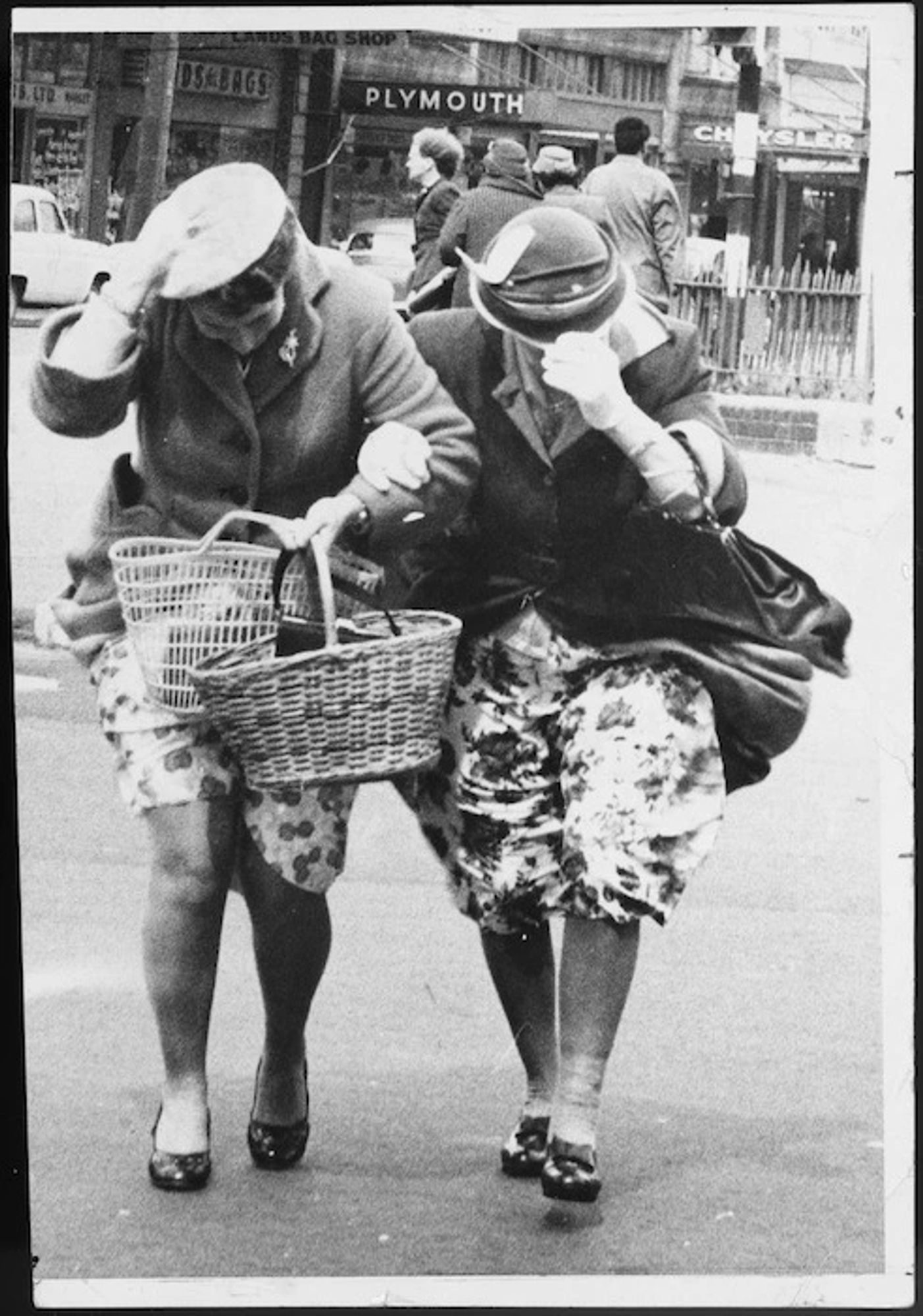 Women battling against the wind as they cross a Wellington city street.
Evening Post.