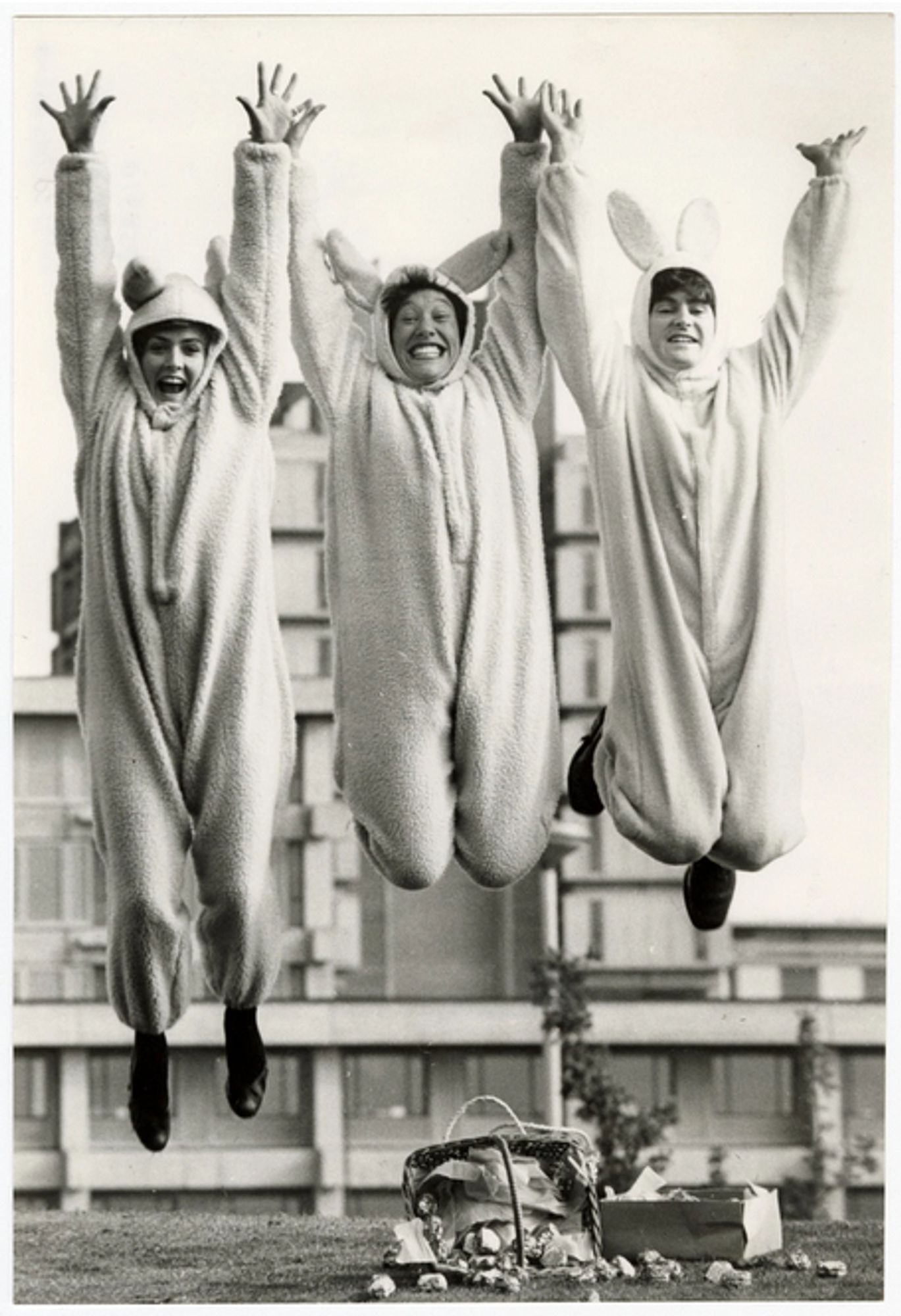 Three women dressed as rabbits, leaping in the air.