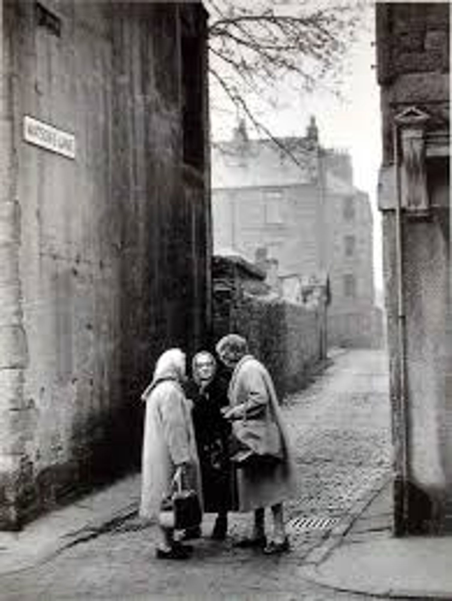 Auld Dundee wifies.  Three women, black and white image on narrow cobbled Lane between tenements.