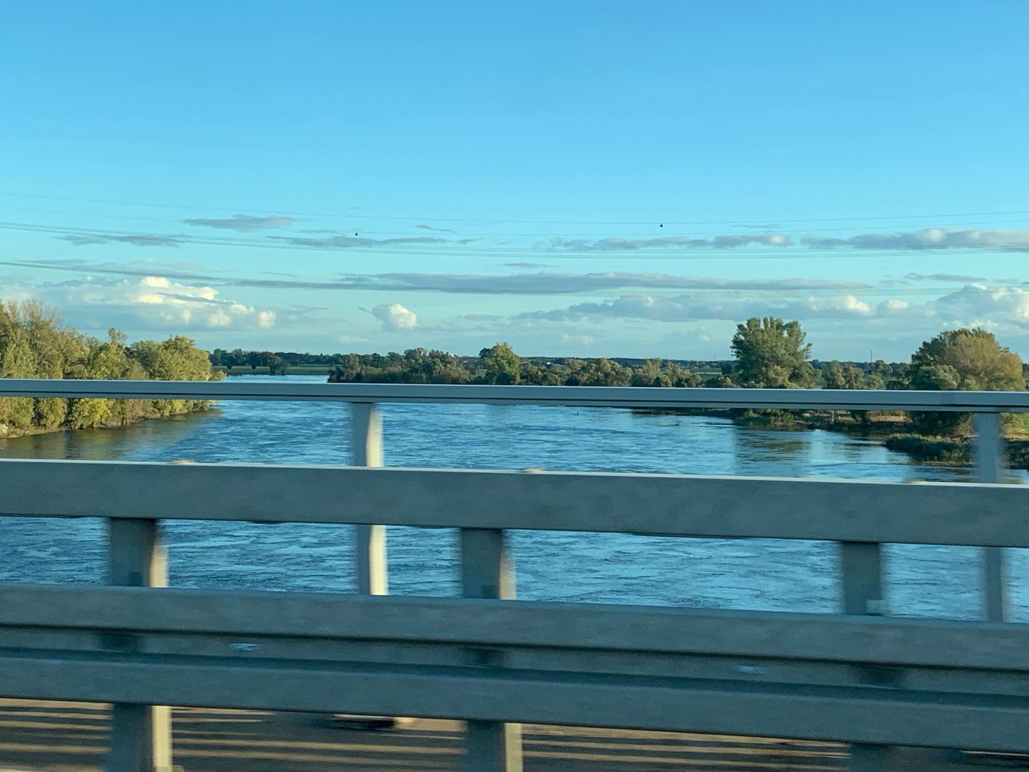 Blick durch die Leitplanken der Autobahn im vorbeifahren auf die Elbe die Hochwasser trägt.