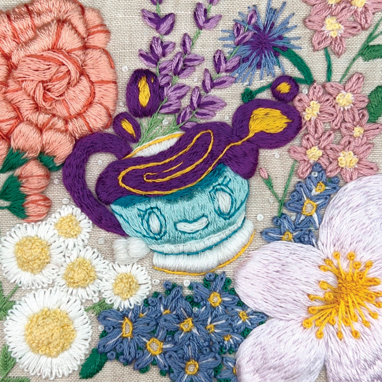 A hand embroidered fanart of the pokemon, sinistea. There’s various pastel colored flowers scattered all around stitched in various ways to mimic the flowers. Sinistea is at the very center with a wide smile and its liquid like ghost form spilling out of teacup body.