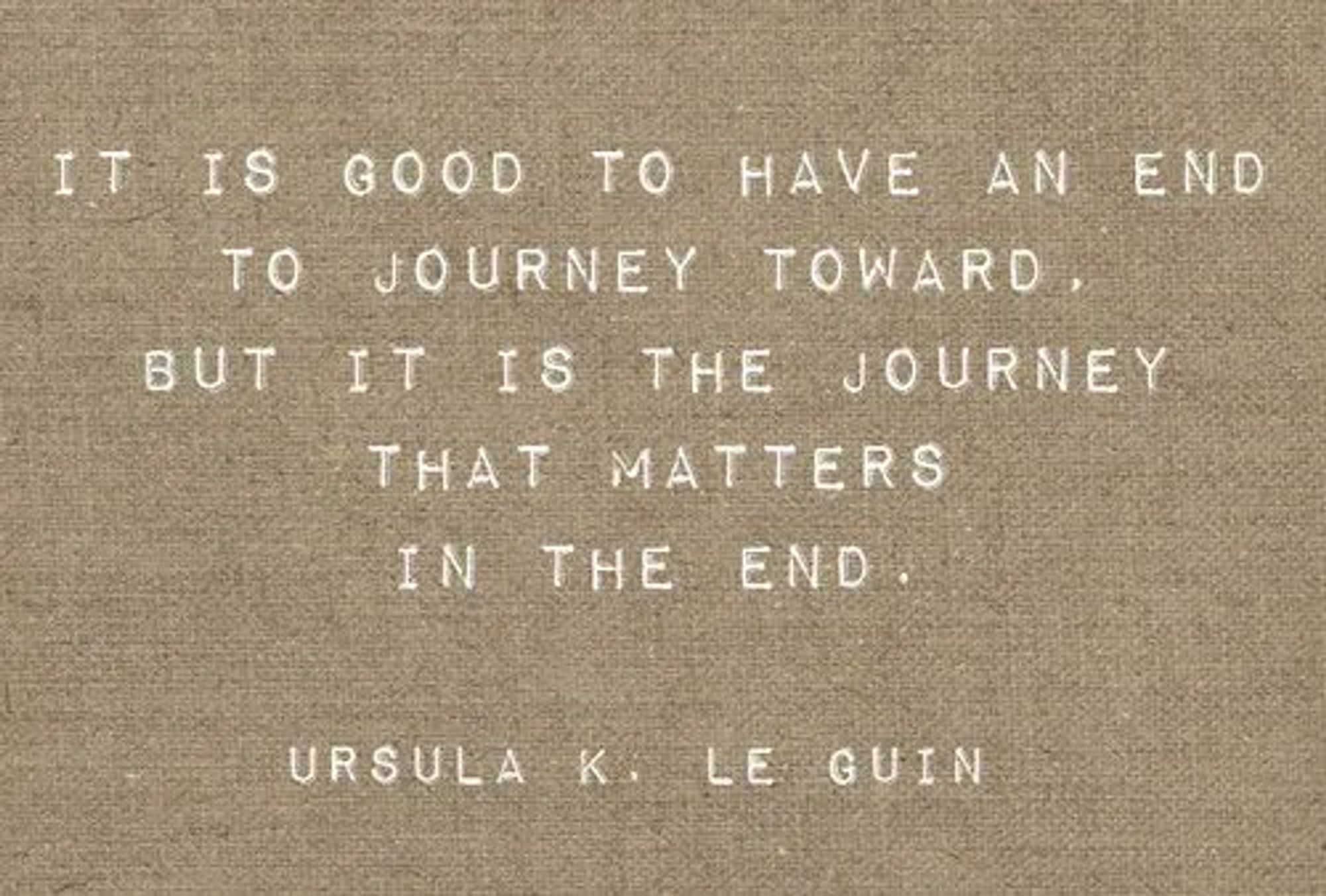 It is good to have an end to journey towards; but it is the journey that matters, in the end. - Ursula K. Le Guin ~ Written on a tan cloth tapestry.