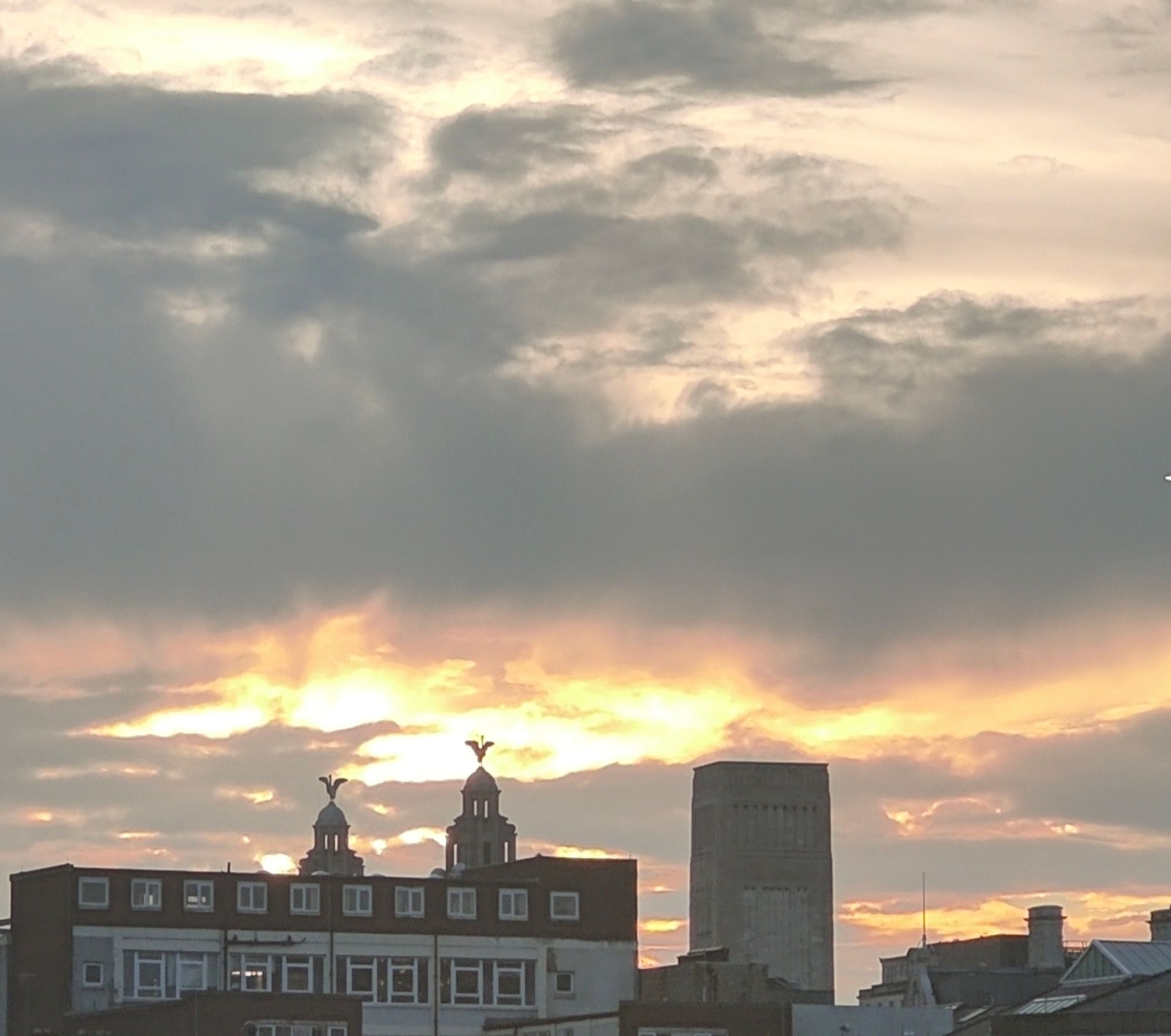 The Liverpool skyline, two Liverpool birds on the Liverpool Building and to the right the solid block of one of the ornate air vents to the Mersey tunnel, yellow and orange lit clouds give a nice evening back drop.
As viewed from the bus station.