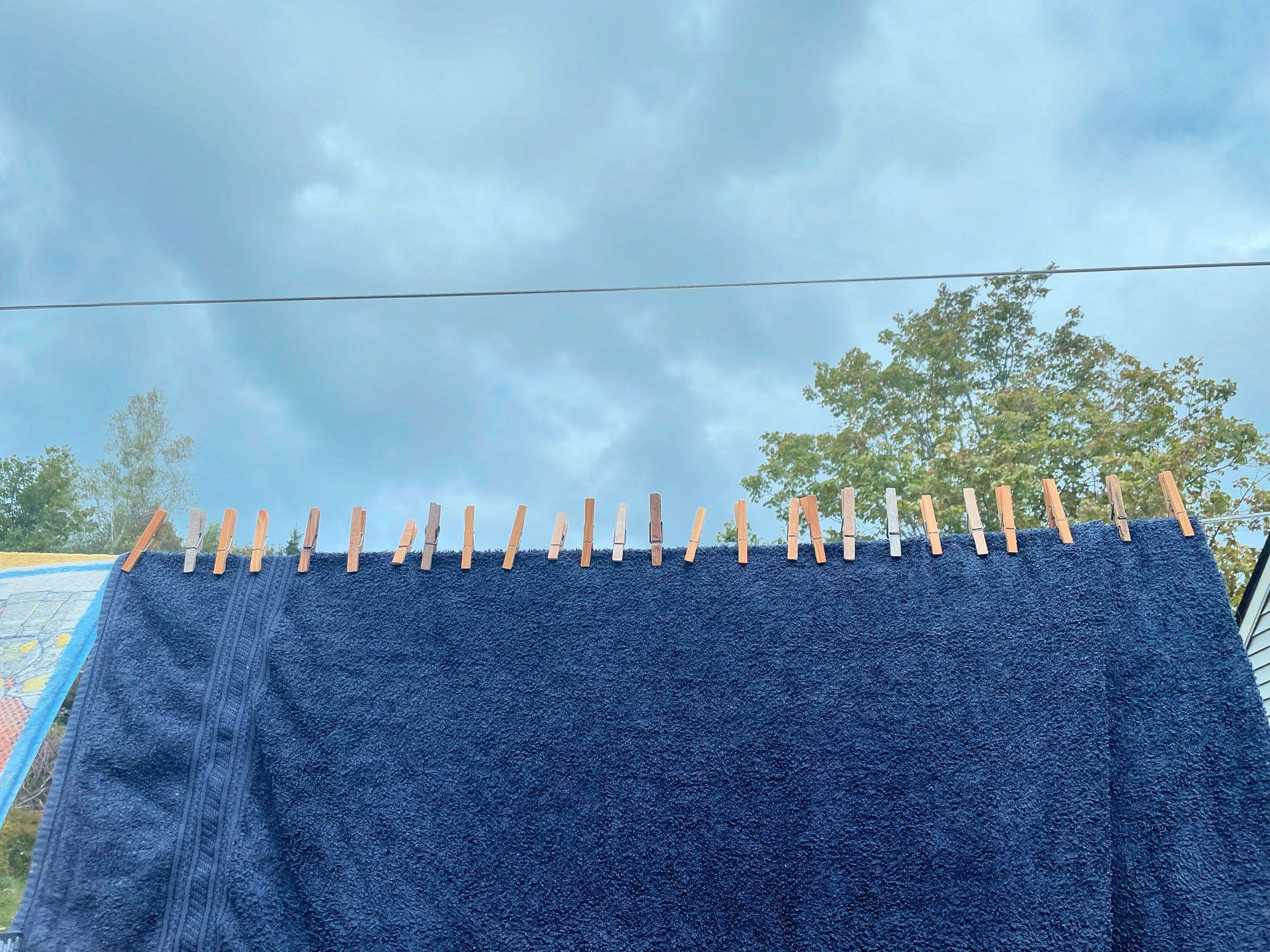 A towel hangs on a clothesline secured with two dozen clothespins because a teenager thought it would be funny.