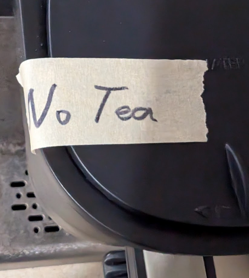 A piece of masking tape with the words, "No Tea" written in marker. The tape is placed over the water receptacle (that's not the right word, but you know what I mean) of a Bunn coffee/tea maker. 