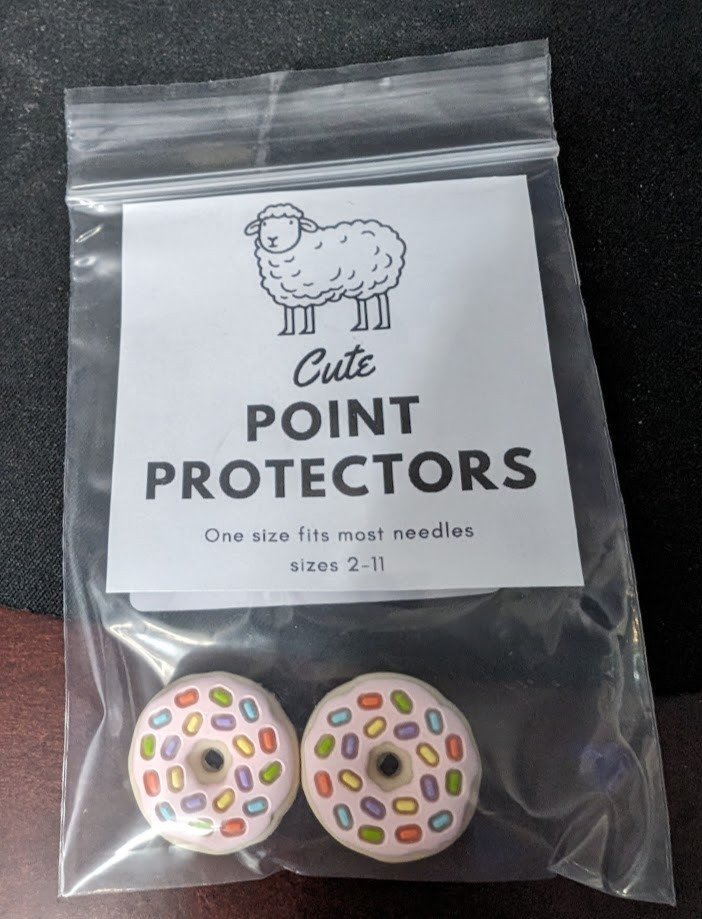 Needle point protectors shaped like sprinkle doughnuts. 