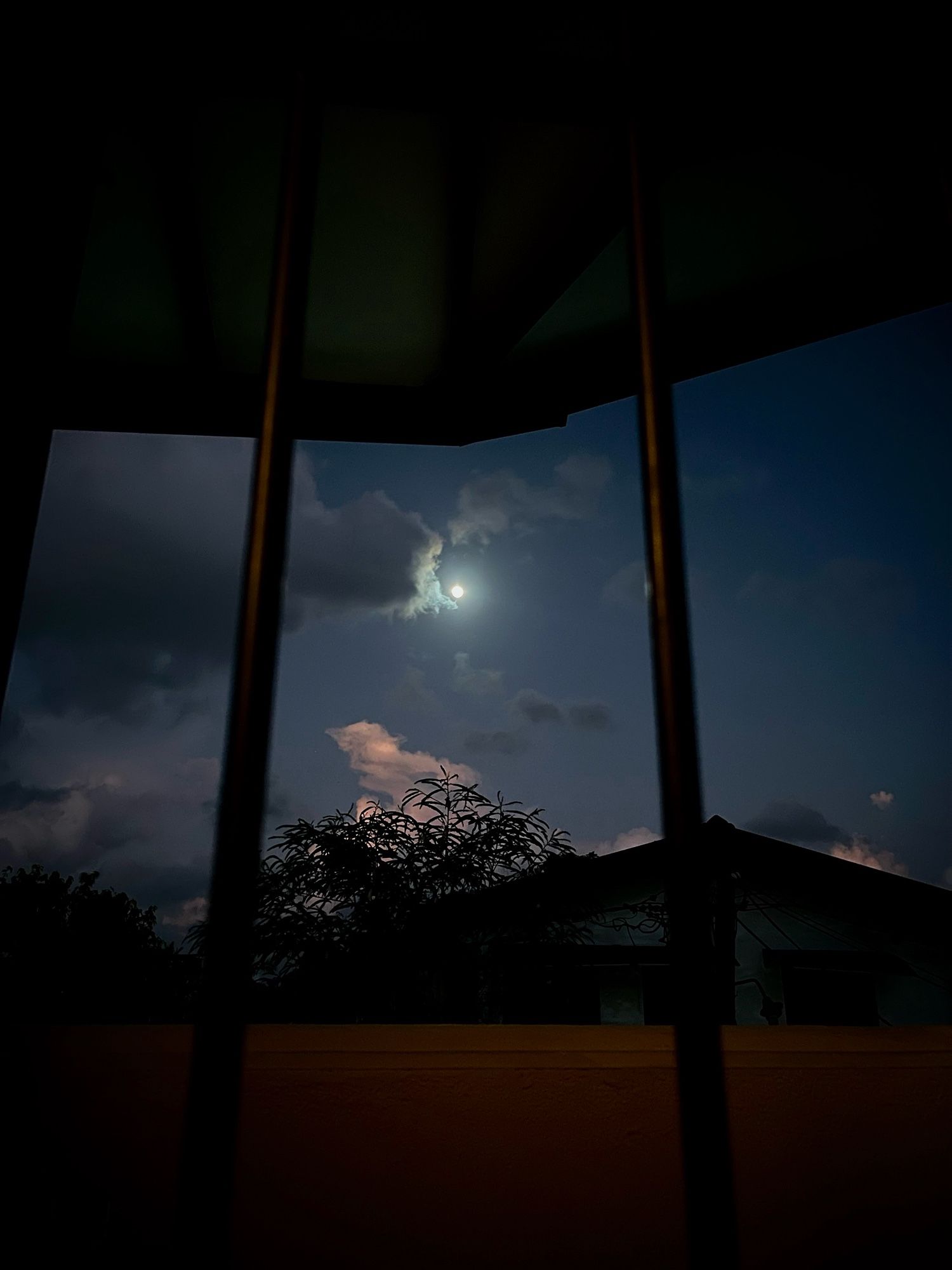 From my bed, I have a beautiful view of the night sky. The moon shines brightly through the window, softly illuminating the clouds as they drift by. It’s a peaceful and serene sight, making the night feel calm and still,,,, 🥹☁️🌛