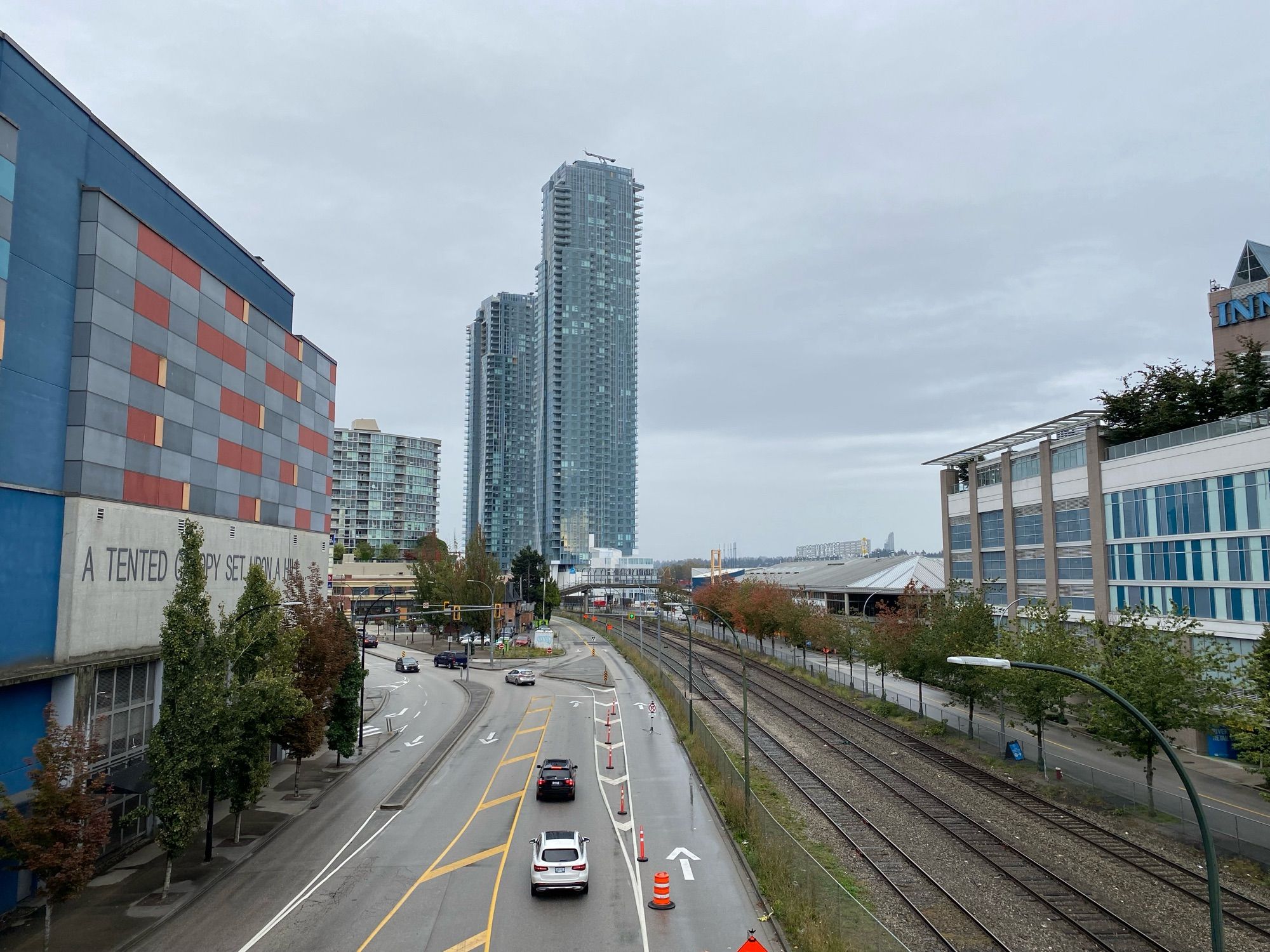 Buildings and train tracks running parallel to a atreet