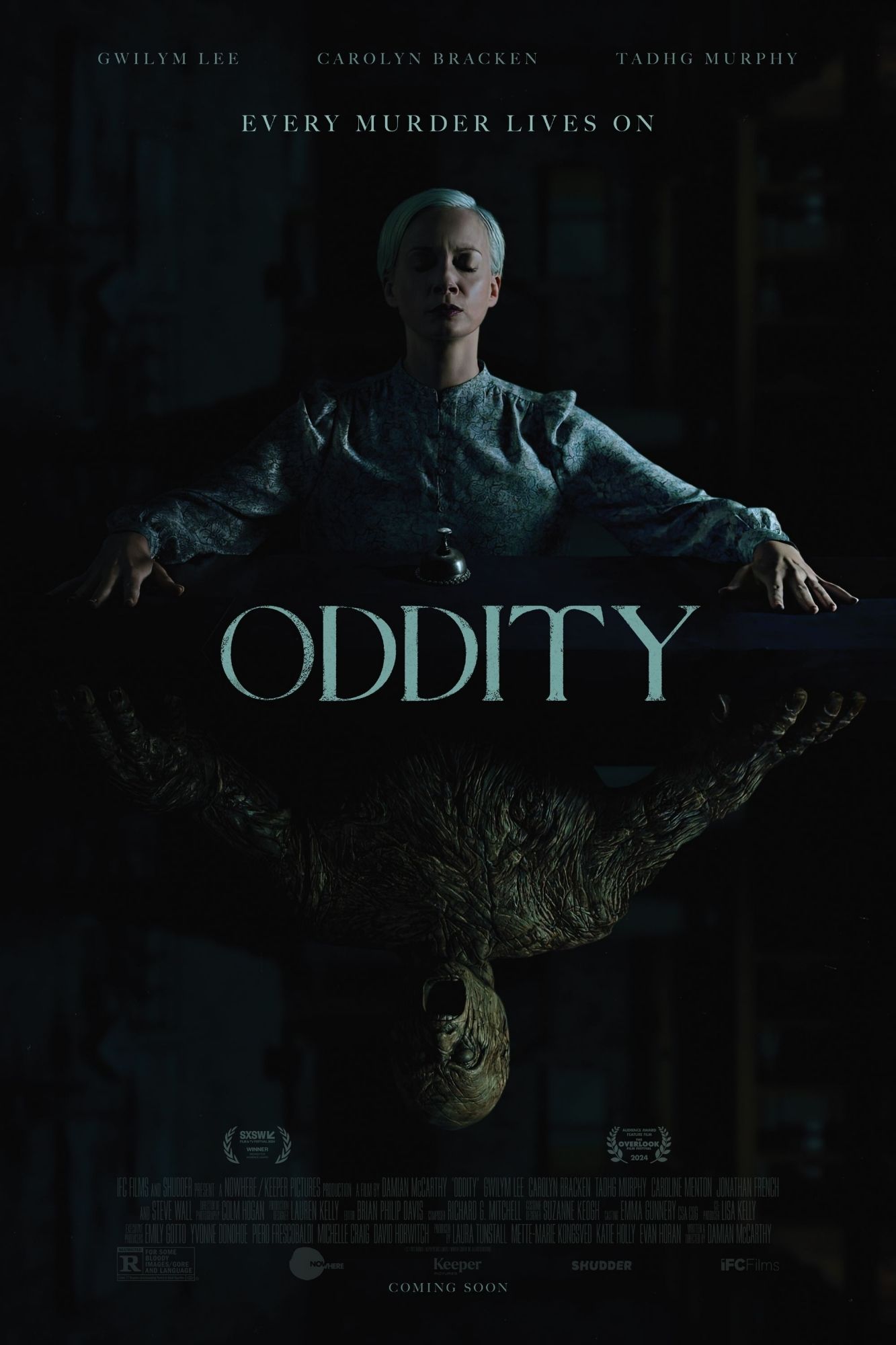 Image is a poster for the 2024 film oddity. It is a woman sitting at a table in meditating trance. Her reflection on the table is a demonic entity