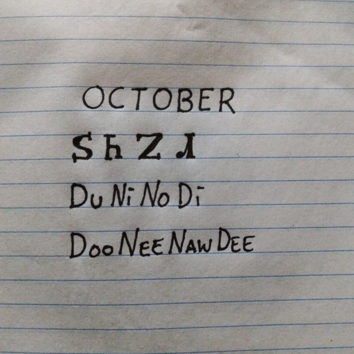 Image is line paper with writing showing an English word and how it is written in the Cherokee language followed by how it is spelled and pronounced. The word is October and pronounced dooneenawdee