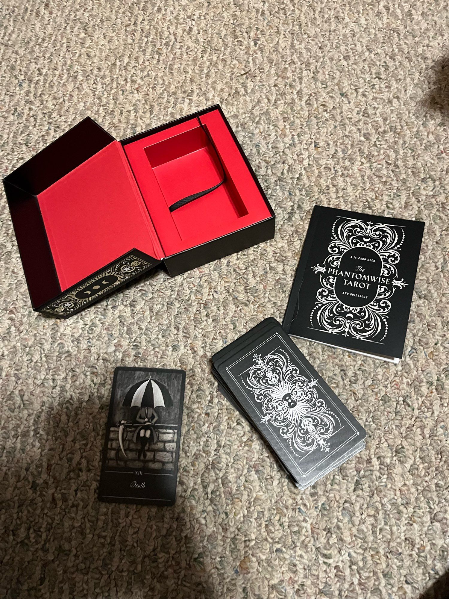 A gorgeous, black and white taro deck, the phantomwise tarot. I’ve pulled the Death card. The box and booklet are visible too.