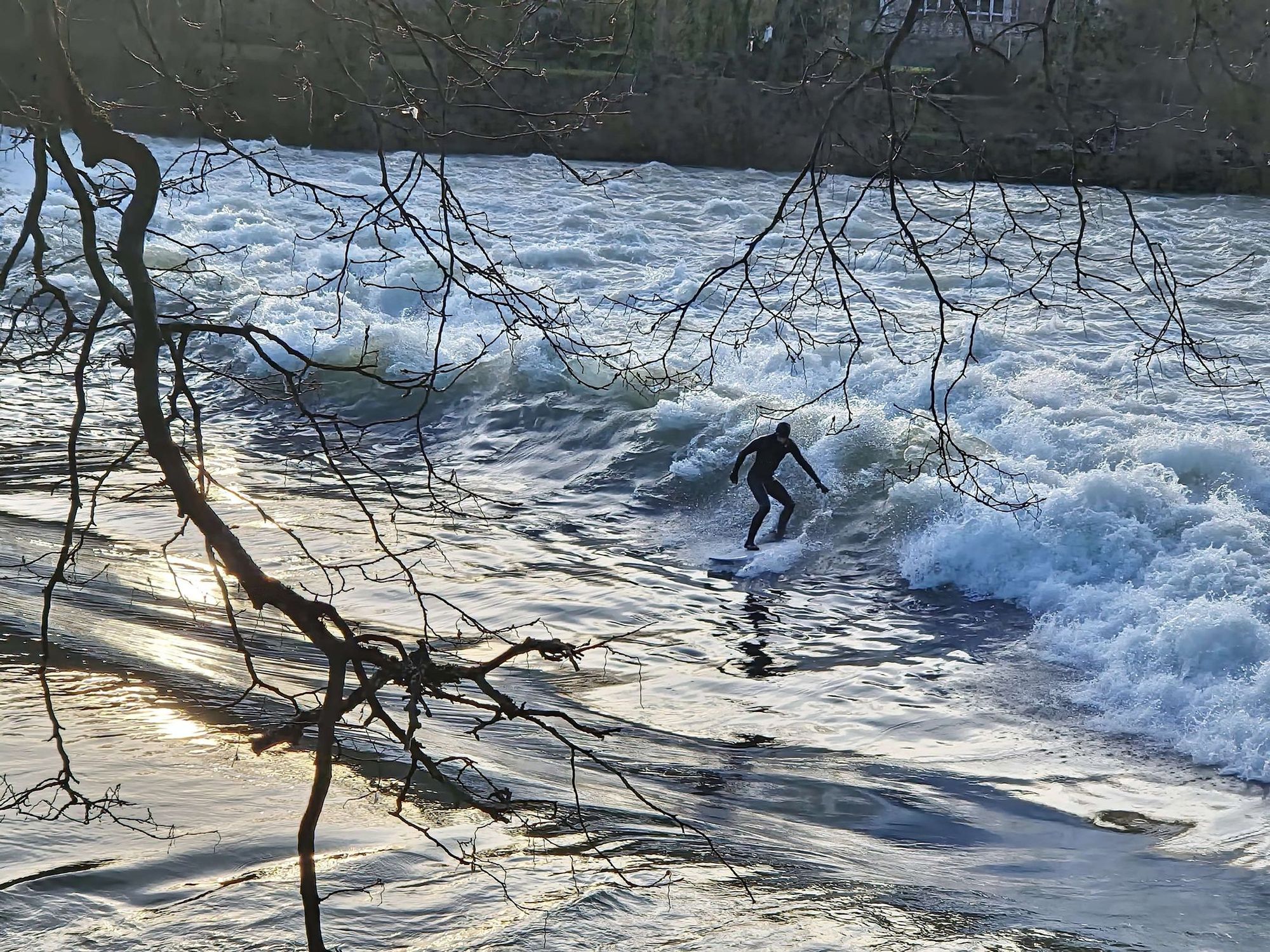 Photo d'un surfer en combinaison qui... ben qui surfe (ouais, c'est un surfer, je l'ai déjà dit ?) sur la vague du parc Micaud à Besançon.