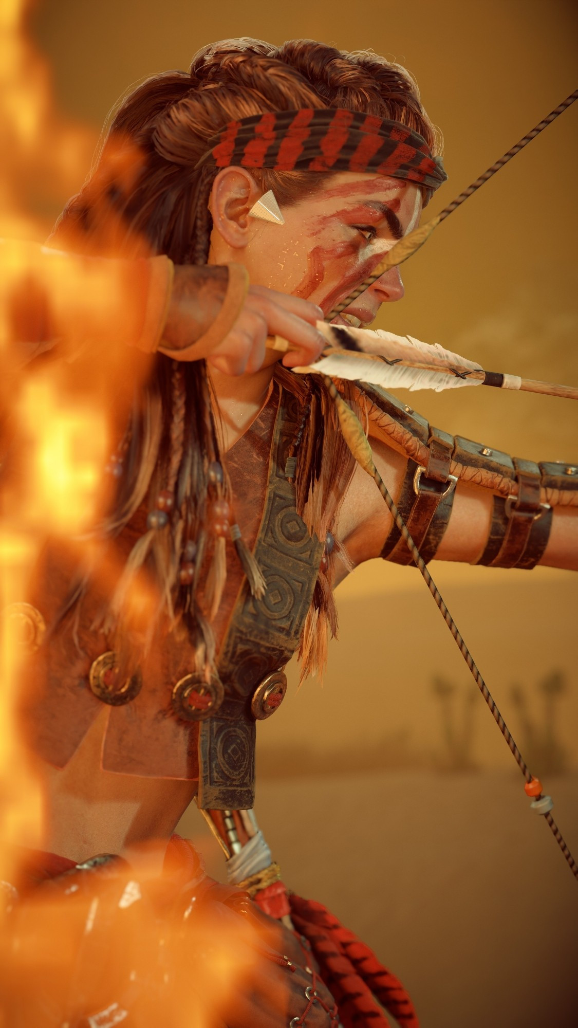 Aloy (video game character from Horizon Forbidden West) aiming with her bow, with a red face painting and flames in front of her.