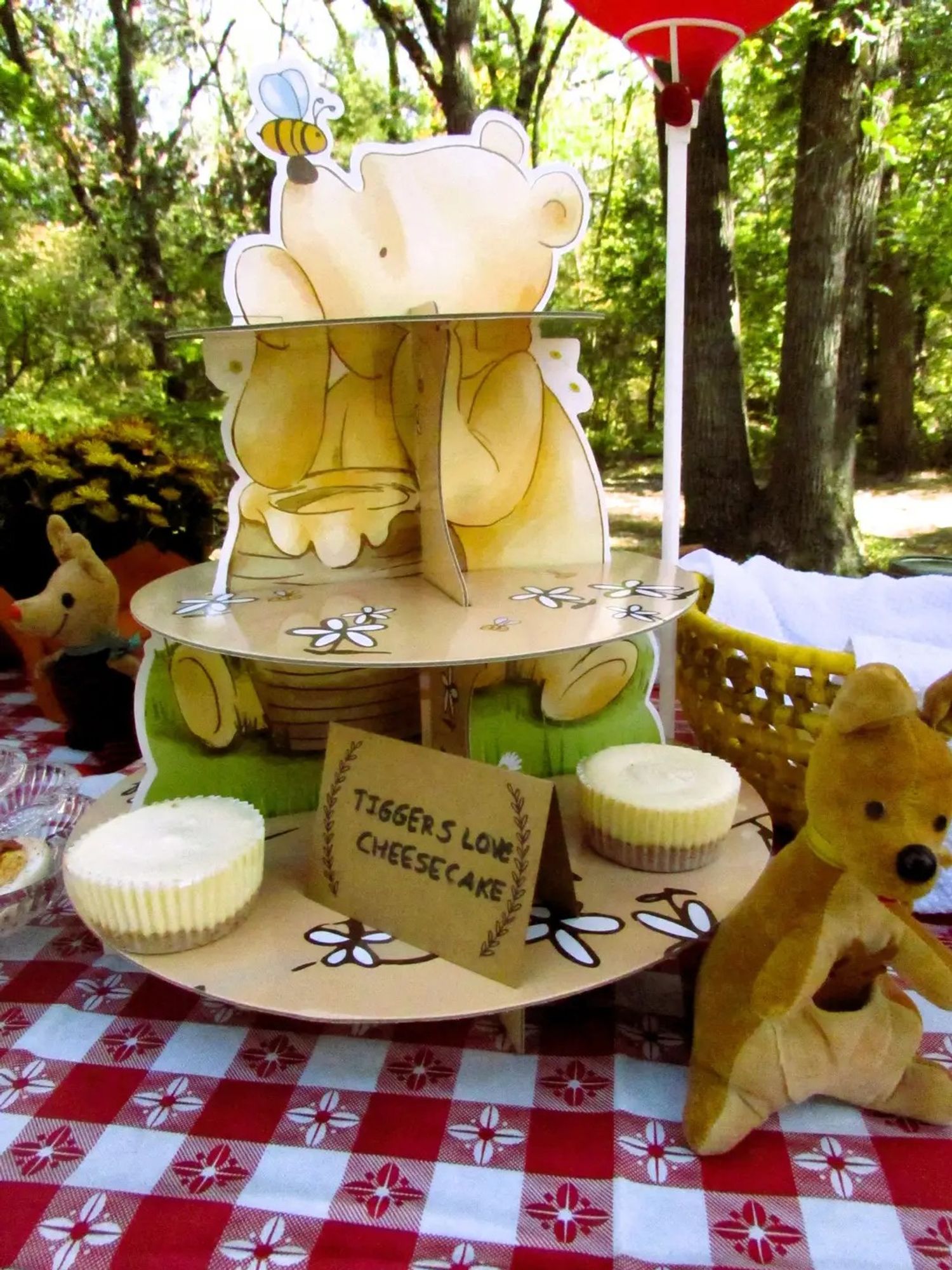 A little tiered Pooh cake holder with mini cheesecakes and a sign reading "Tiggers love cheesecake".