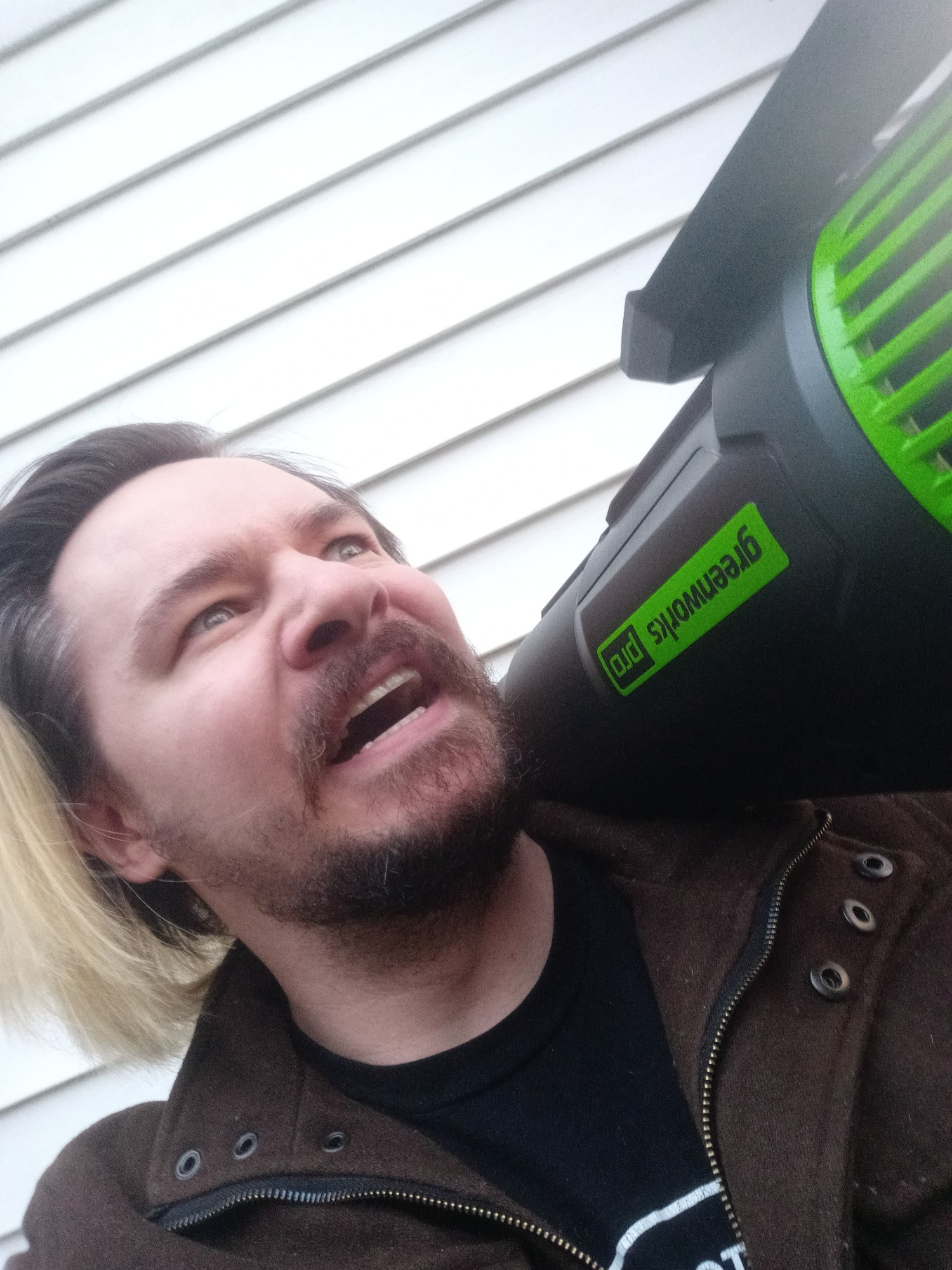 An idiot with an upside-down leaf blower hoisted onto his shoulder prepares for a skirmish with a battle cry.  His lawn-cleaning rocket launcher glows green with power.