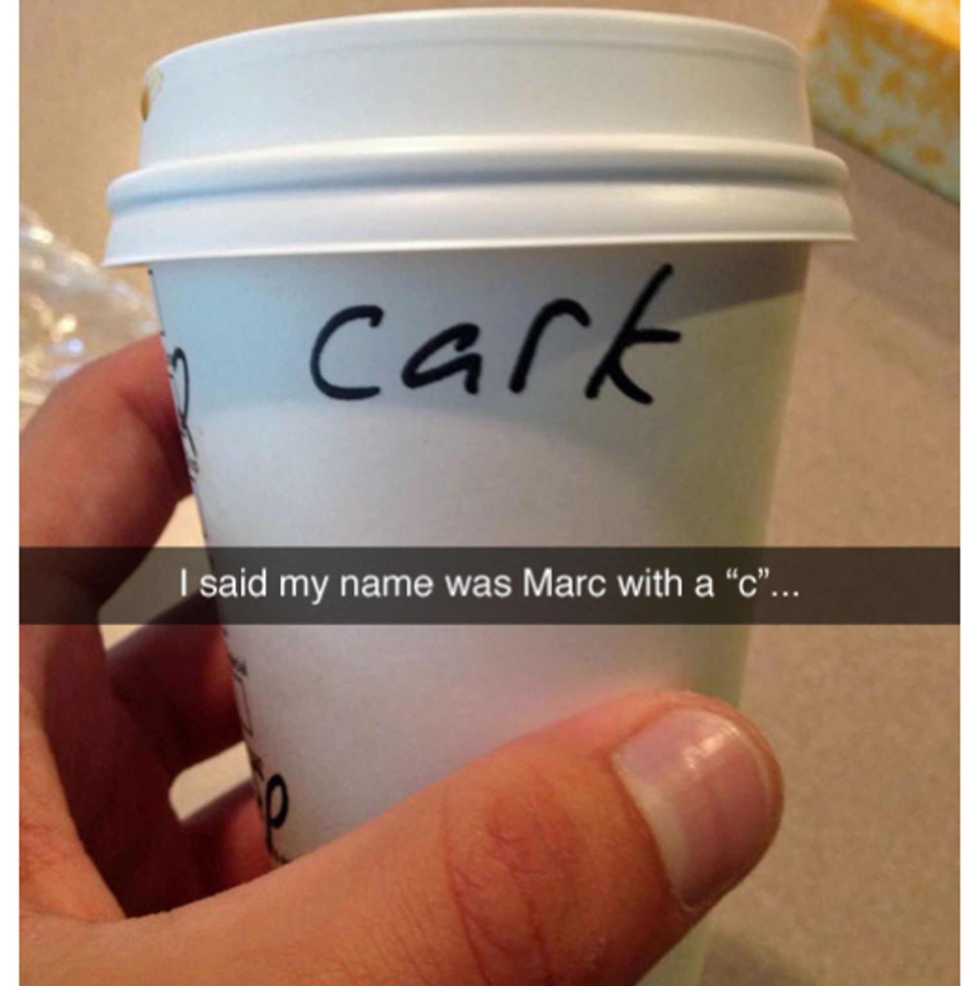 A photograph of a Starbucks cup with the word “cark” written on it in black Sharpie. Caption says “I said my name was Marc with a “c”…”