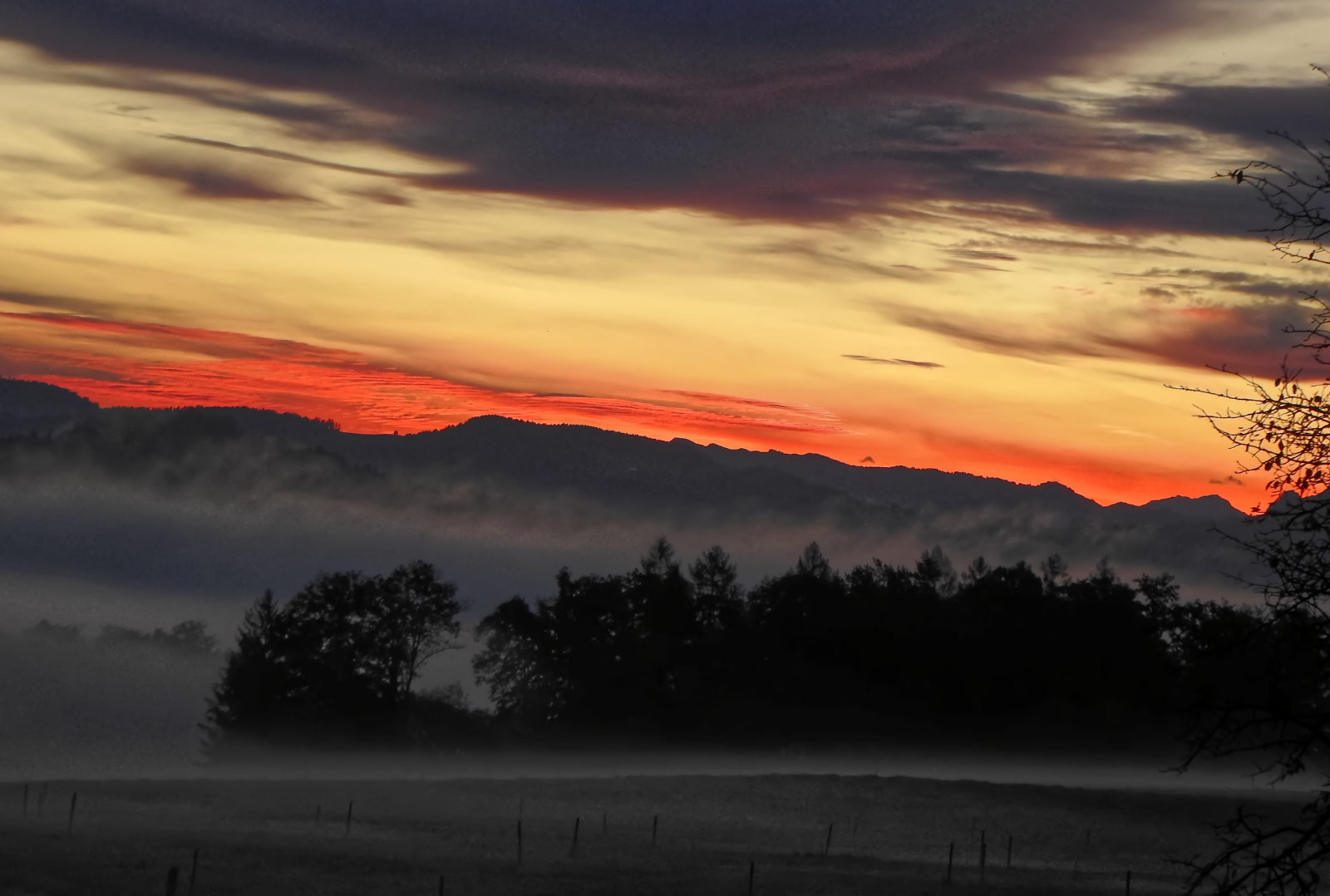 Sunrise over trees/hills