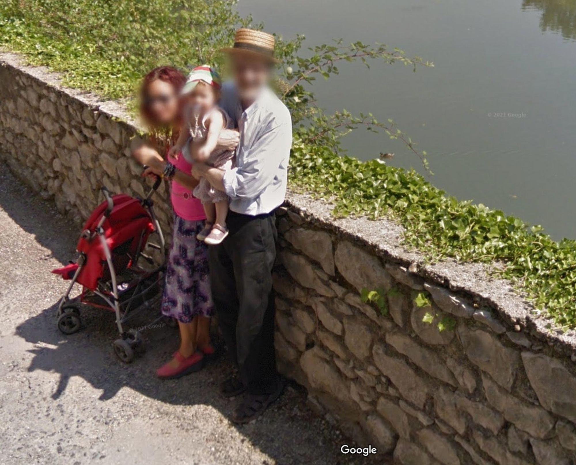 Robert Crumb on Google maps. He holding a baby and standing against a wall to let the Google van pass.  The baby's mother is beside him.