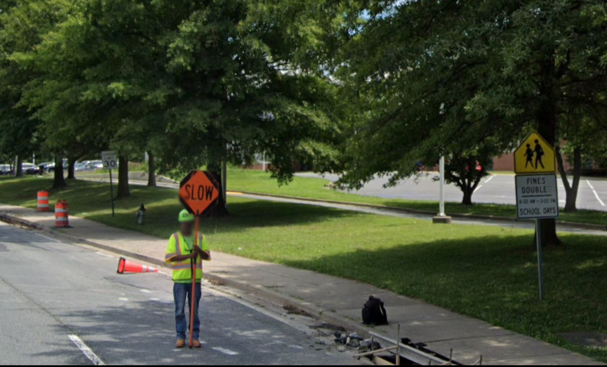 Google Streetview of Rock Spring Drive in front of Walter Johnson High School. There is a school zone sign, and there is a 30 mph speed limit sign.