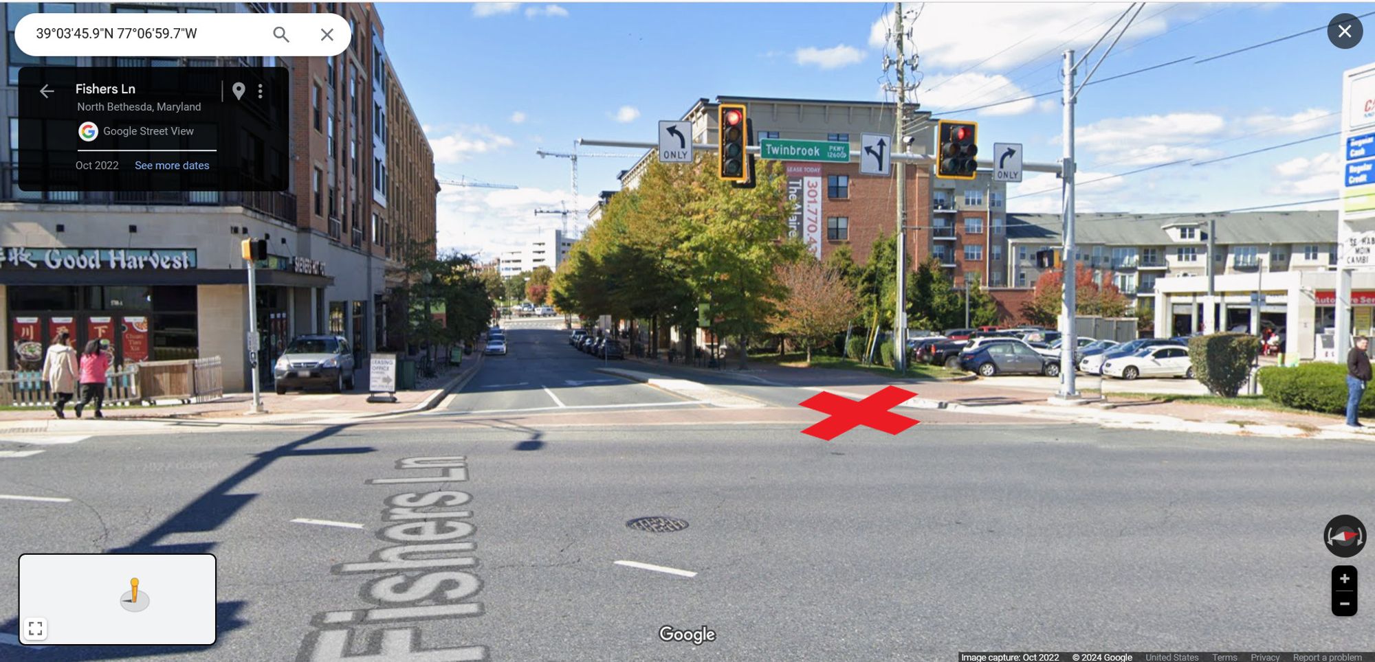 Google Streetview of a large four-way intersection with a traffic signal. There is a restaurant on one side of a marked crosswalk, and a gas station on the other side. There is a red X in the marked crosswalk to indicate the location of the crash. There are pedestrians on both sides of the street.