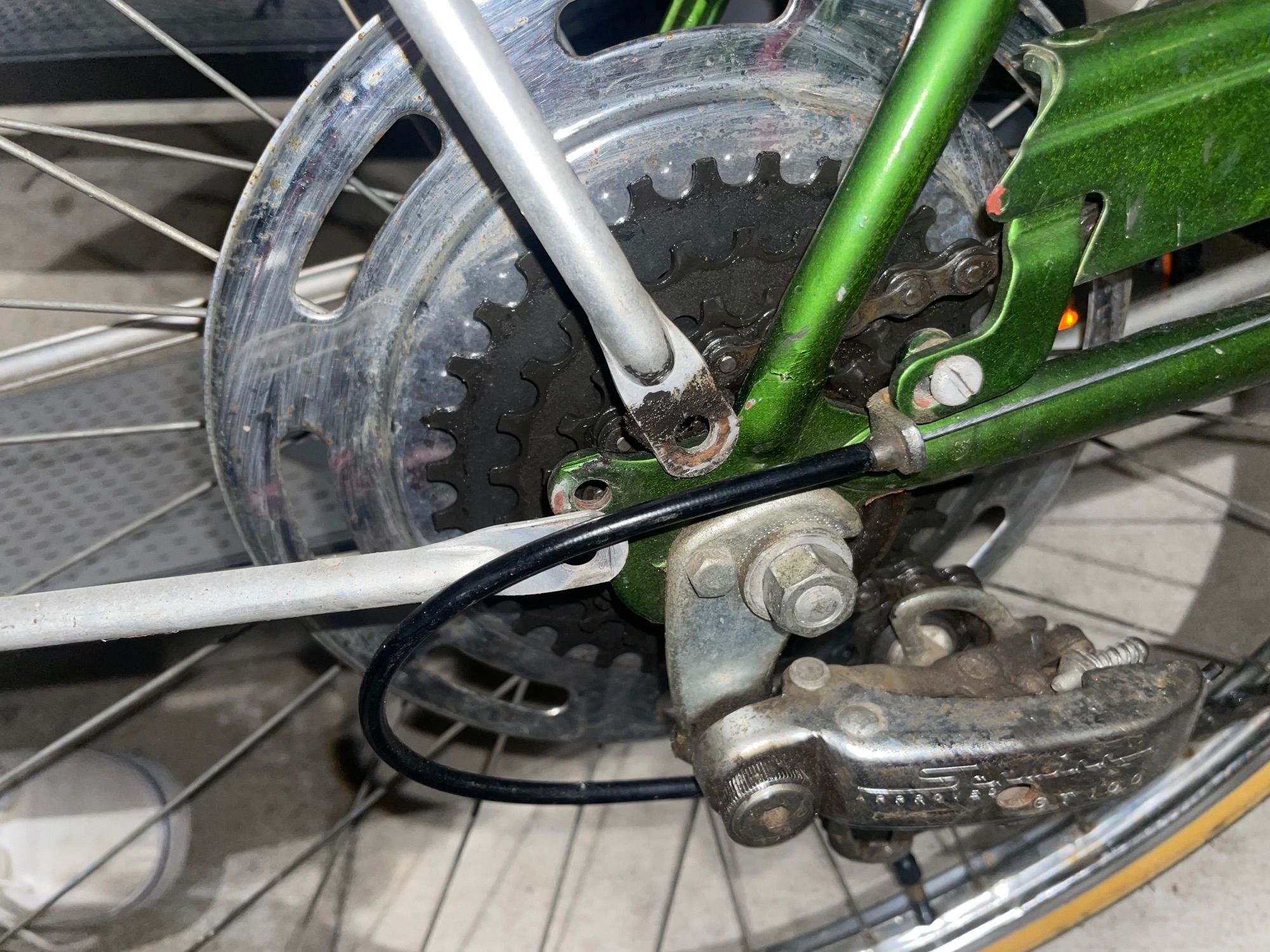 A bike back fender, which should be attached to the frame on the derailleur side with a bolt, but the bolt is missing.