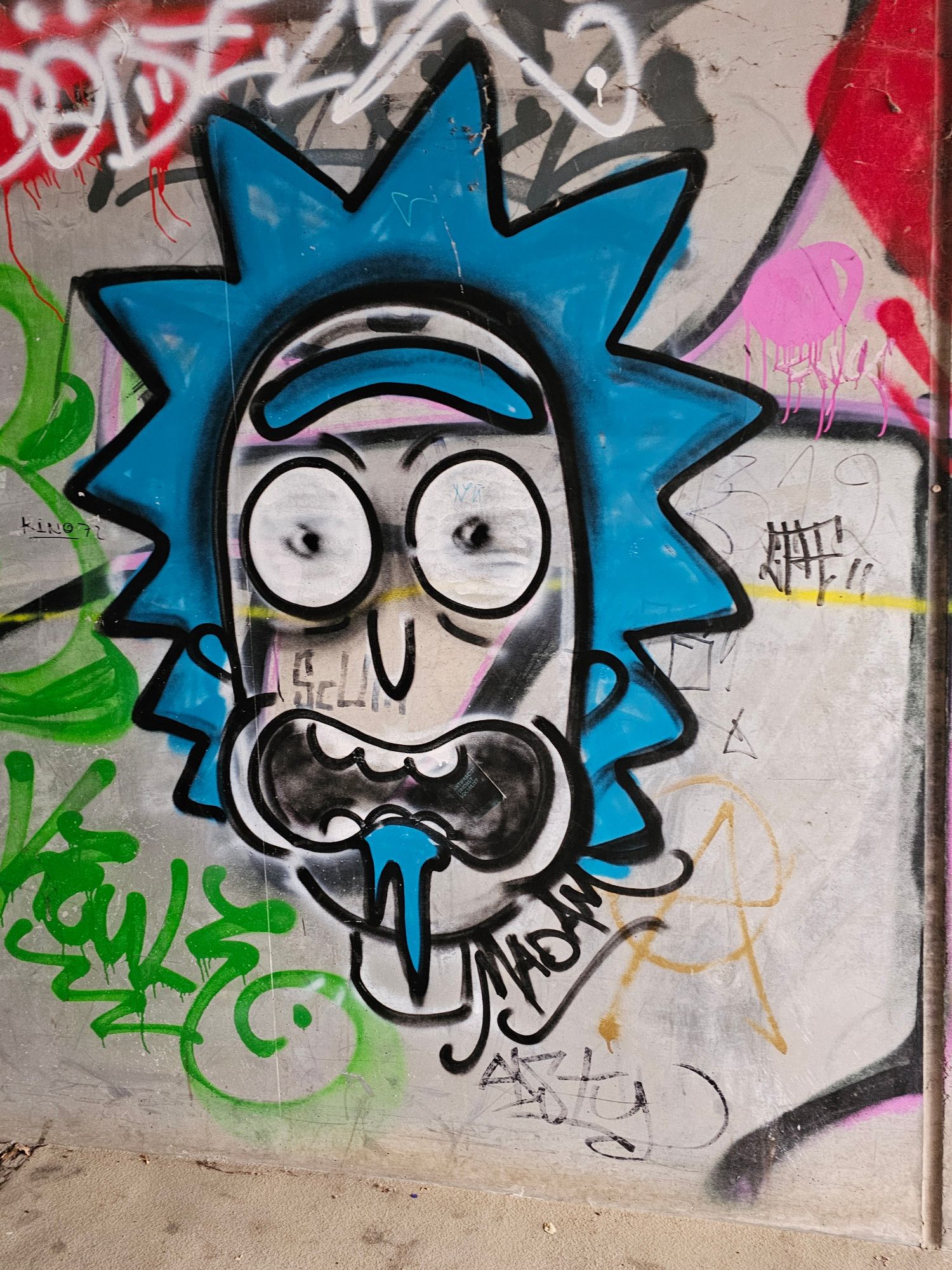 A crazy face with spiky blue hair, a blue unibrow, bugged out eyes, and blue saliva dripping out of its freaked out mouth