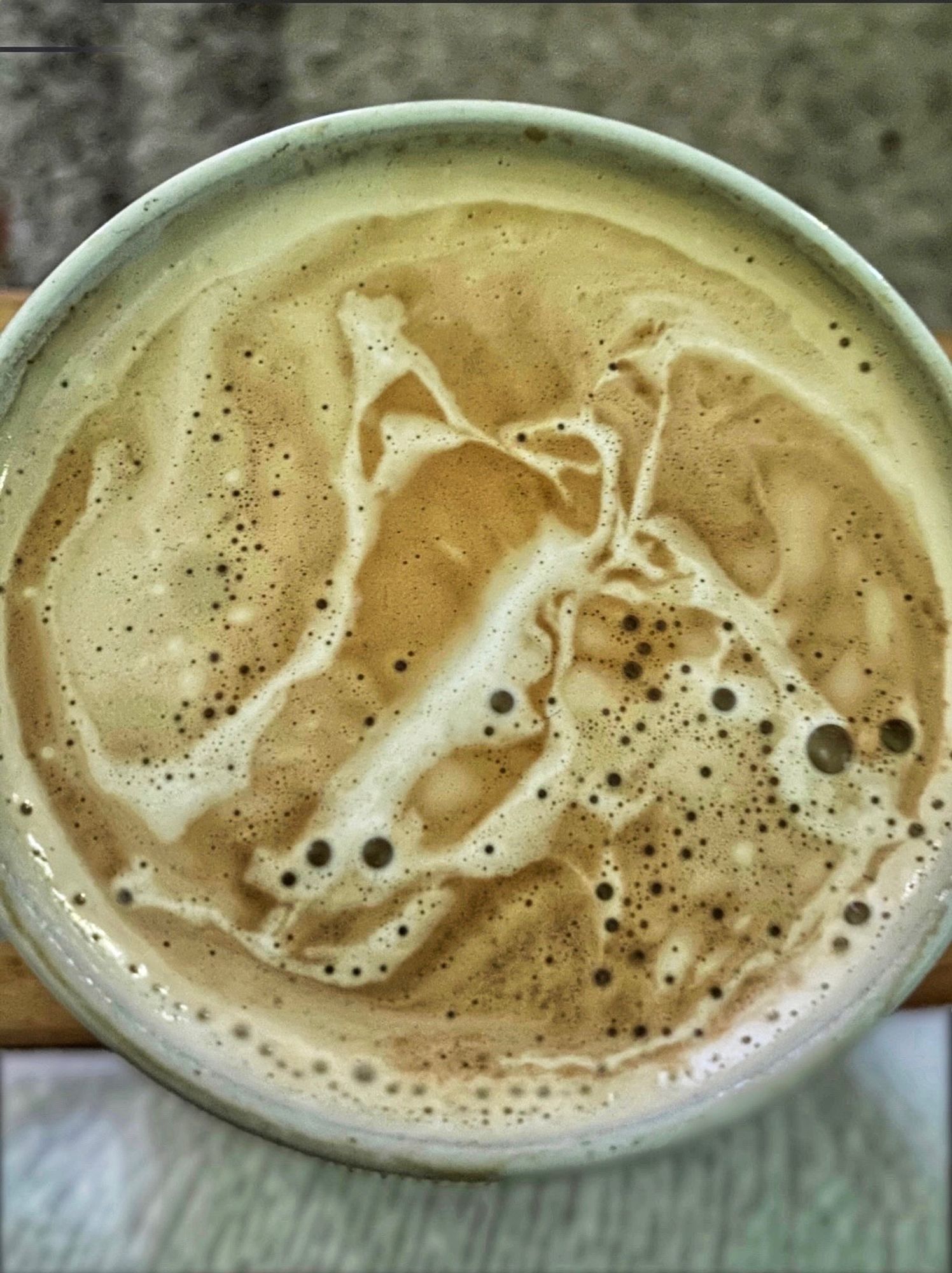 Blick in eine Kaffeetasse mit zufälliger Barista-Kaffeeschaumkunst.