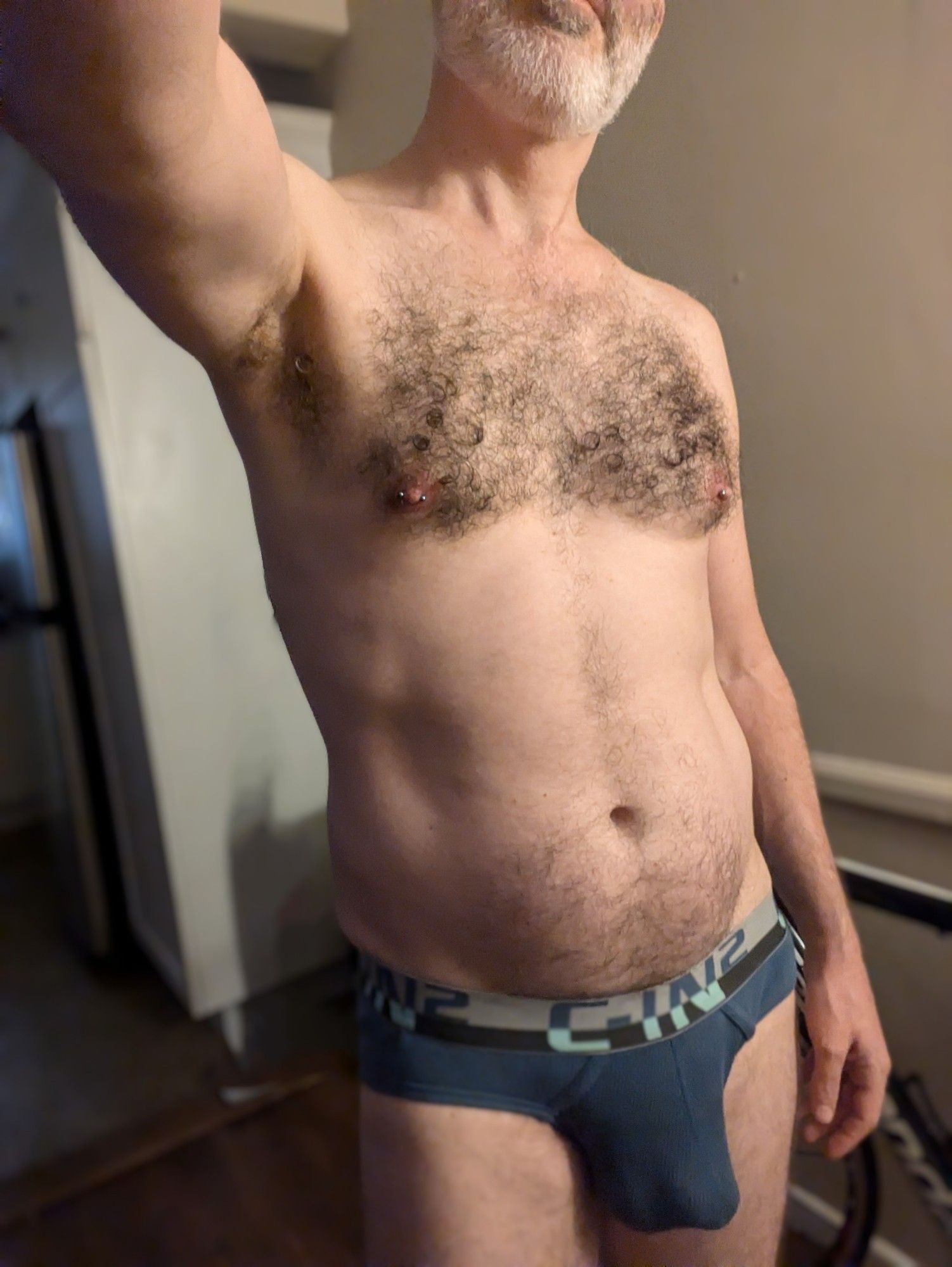 Headless selfie of a furry chested white guy in blue CIN2 low rise briefs