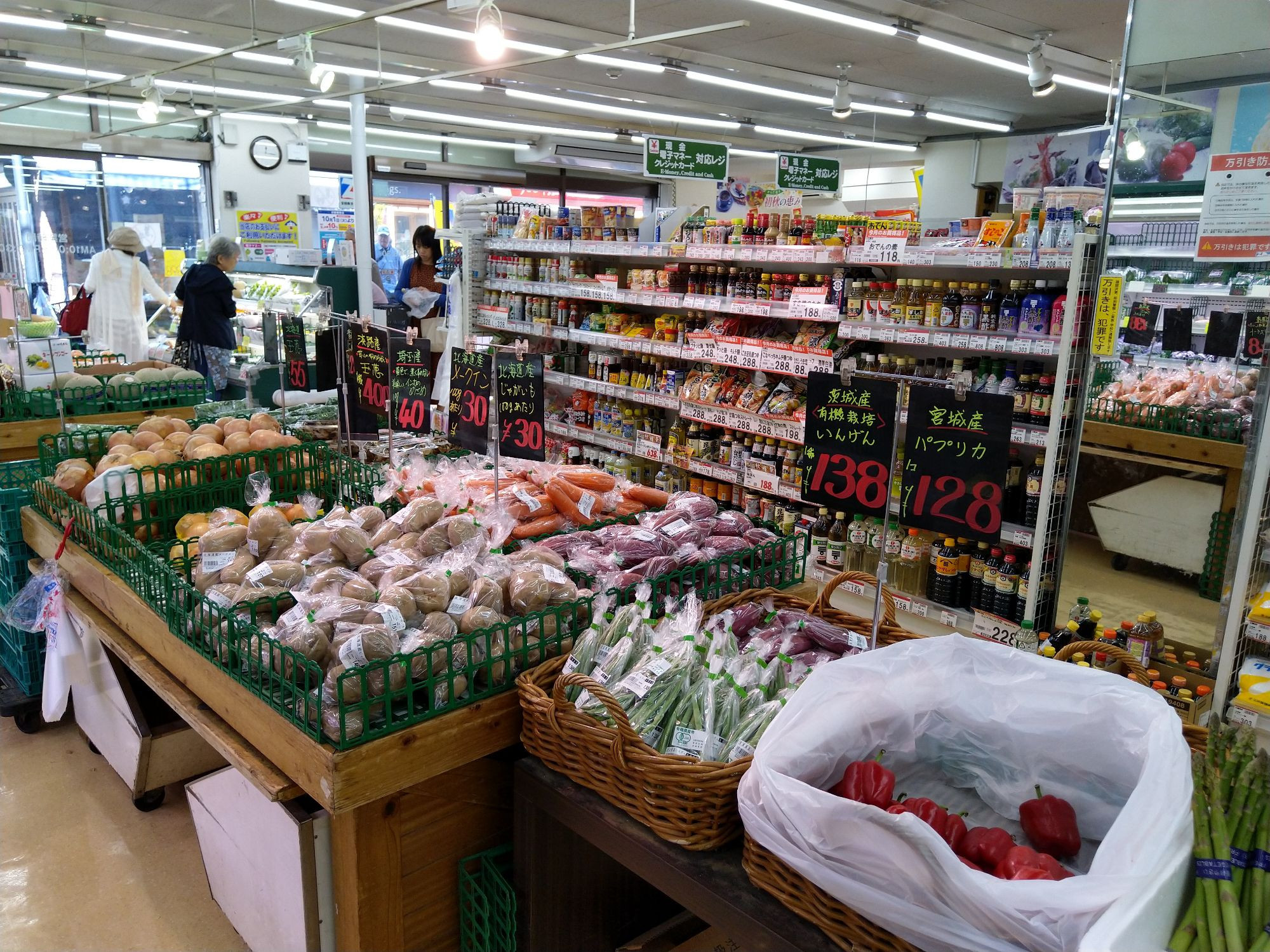 Kleiner Supermarkt für Lebensmittel. Im Hintergrund stehen ein paar Menschen