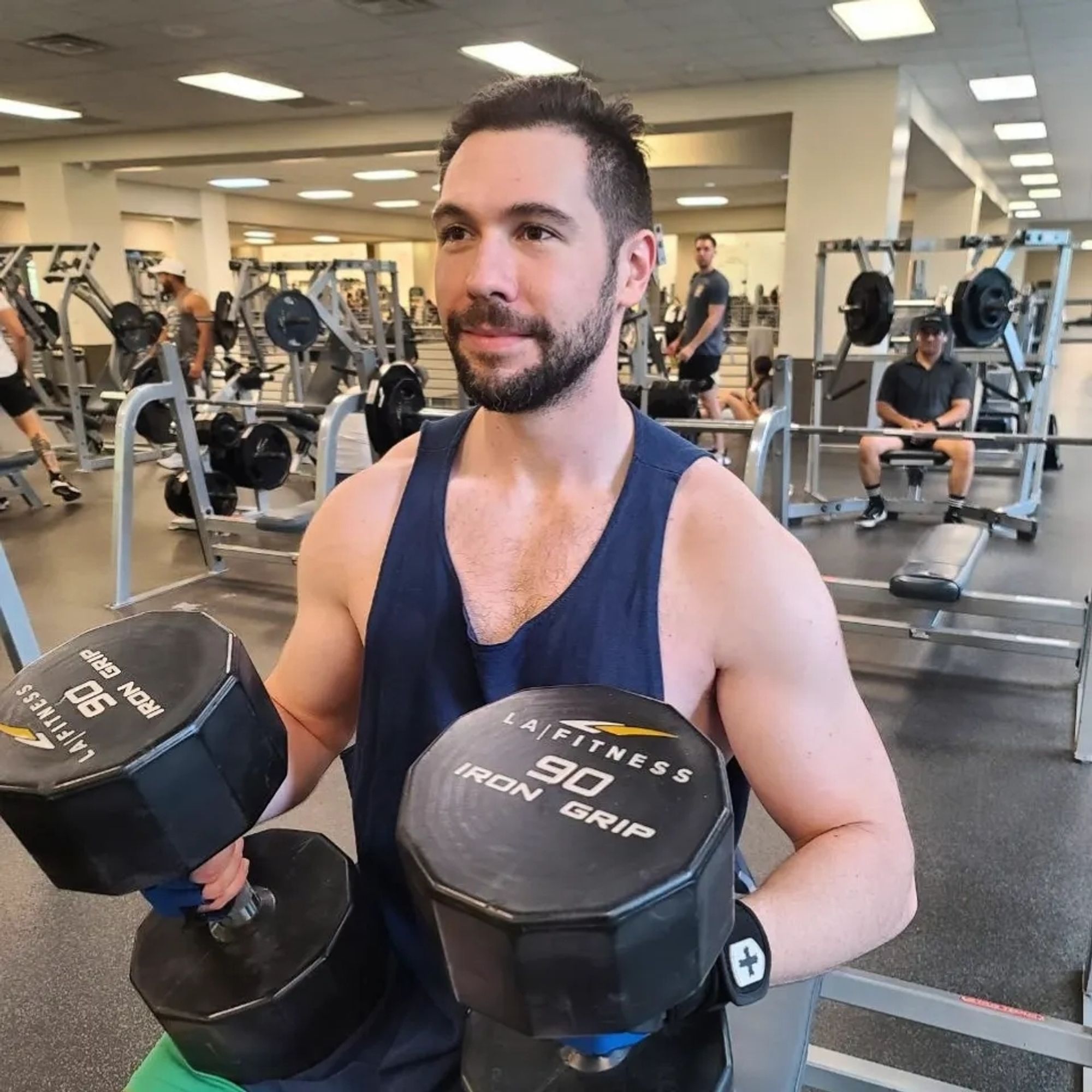 Man mentally preparing for exercise, holding 90 lb dumb bells