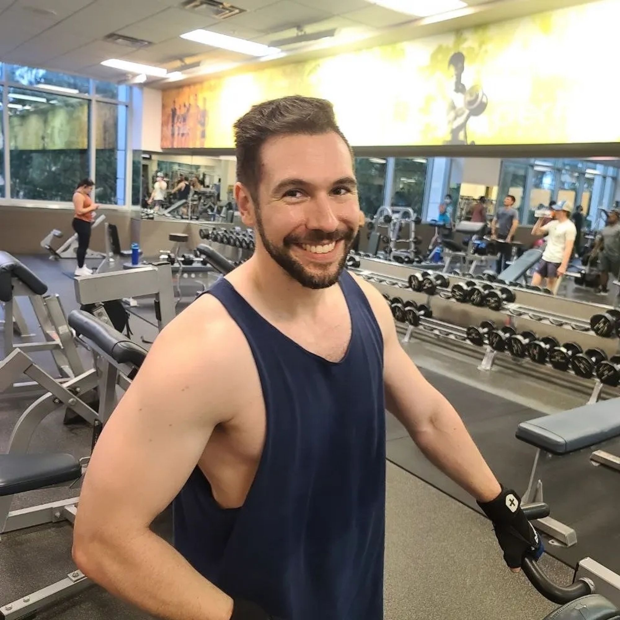 Man smiling in gym in tanktop