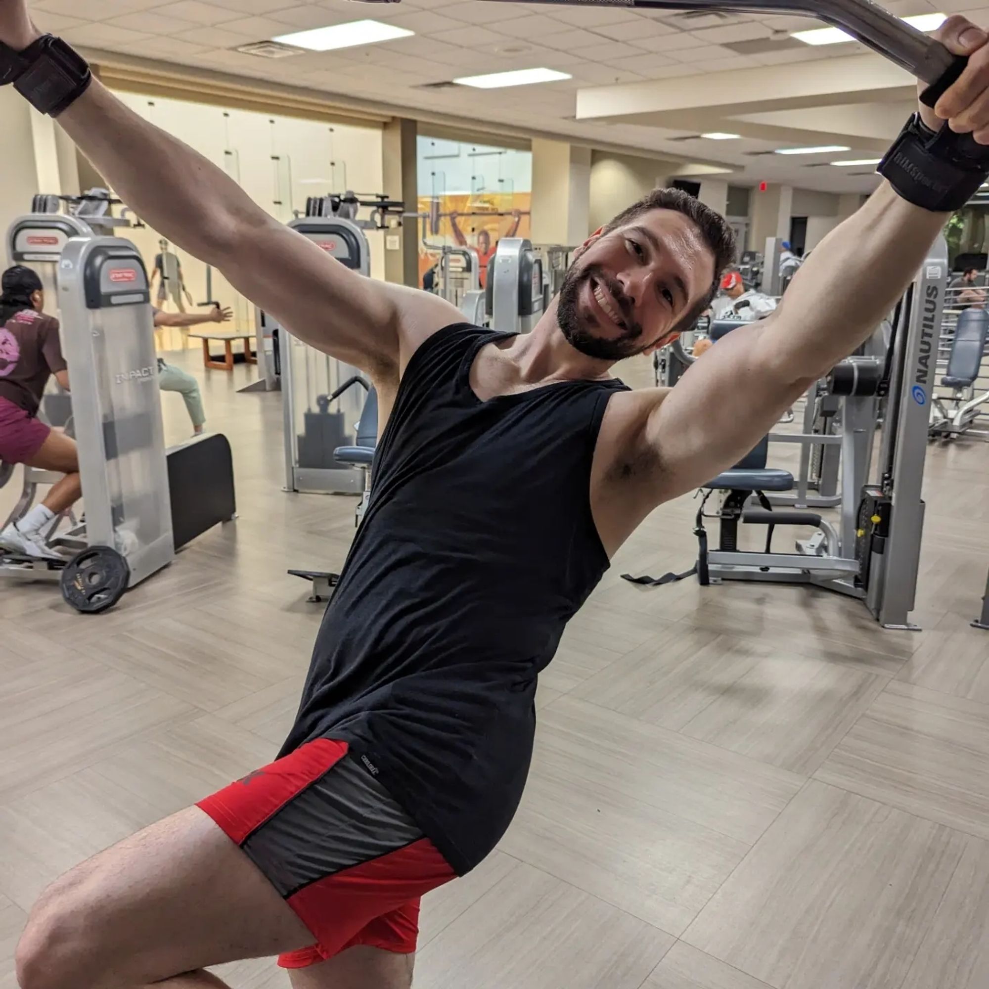 Man making a silly pose from the lat pulldown machine