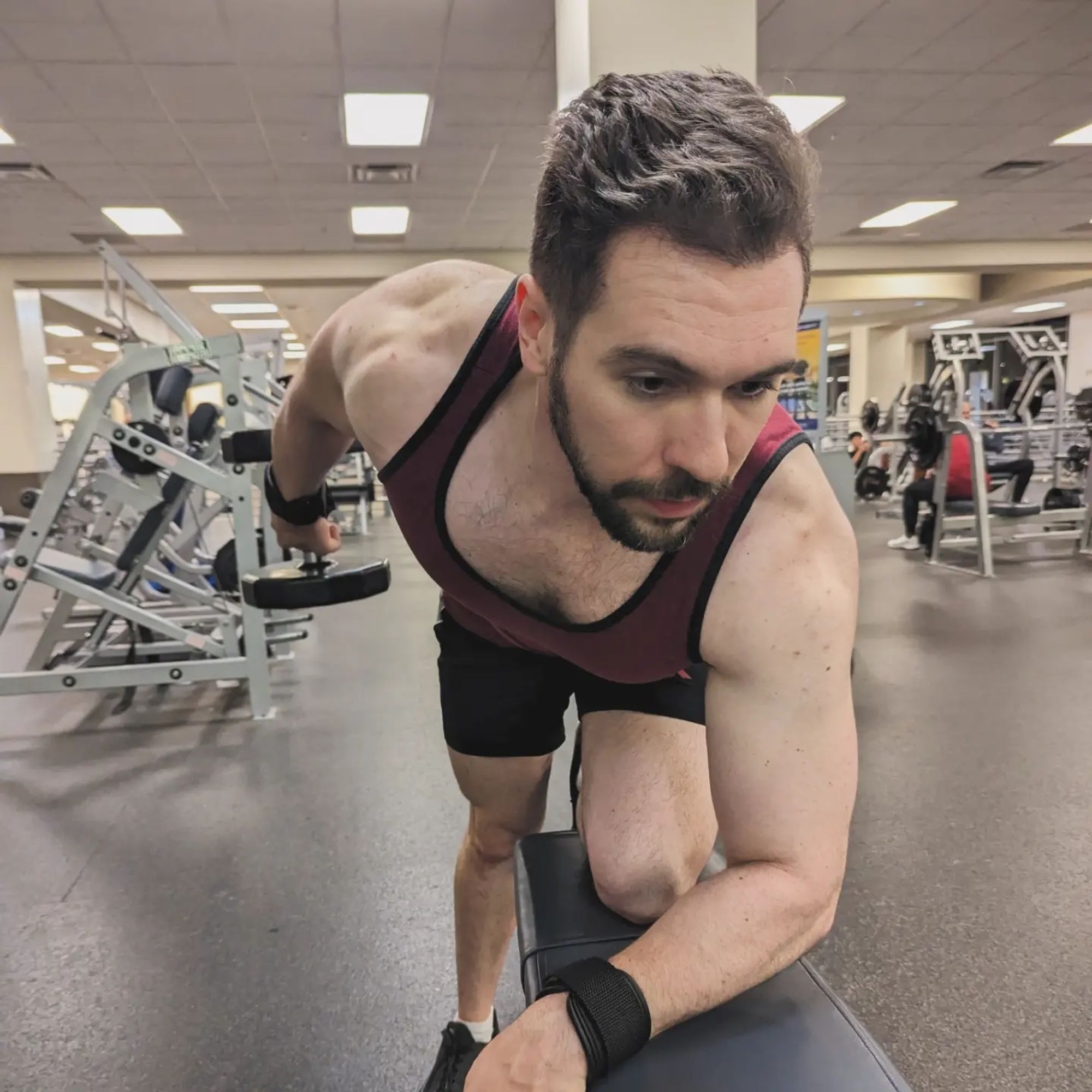 Man doing bent over tricep extensions (you can see his pec cleavage)