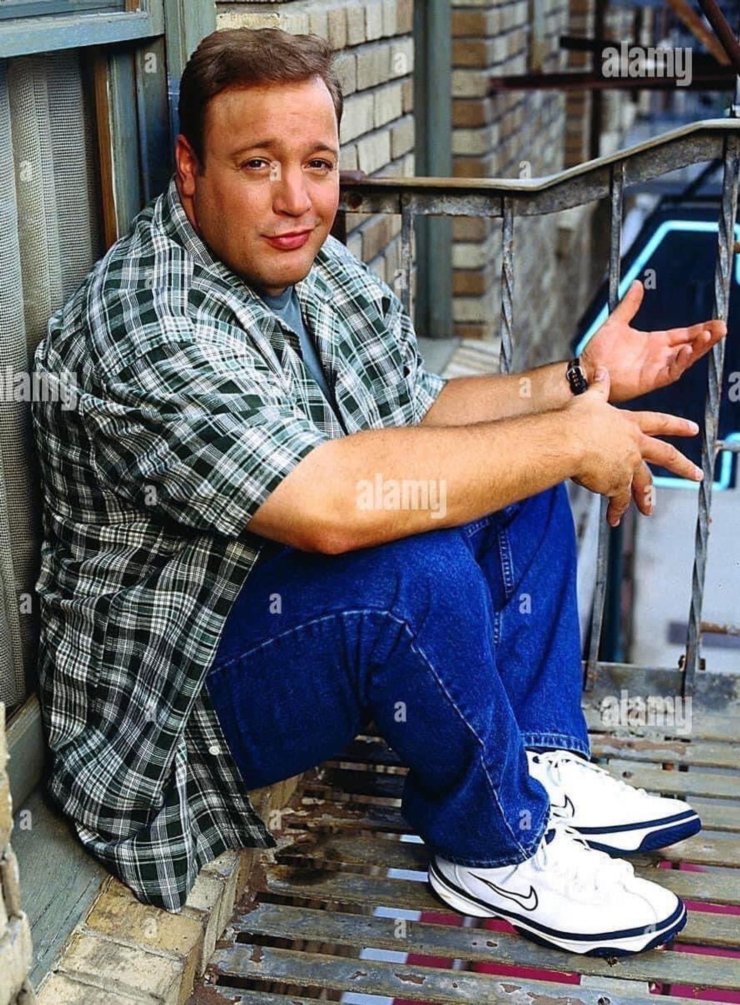 Kevin James sitting and gesturing his hands as if engaged in casual conversation